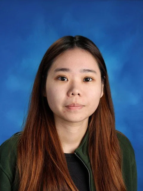 Portrait of a woman with long brown hair against a blue background