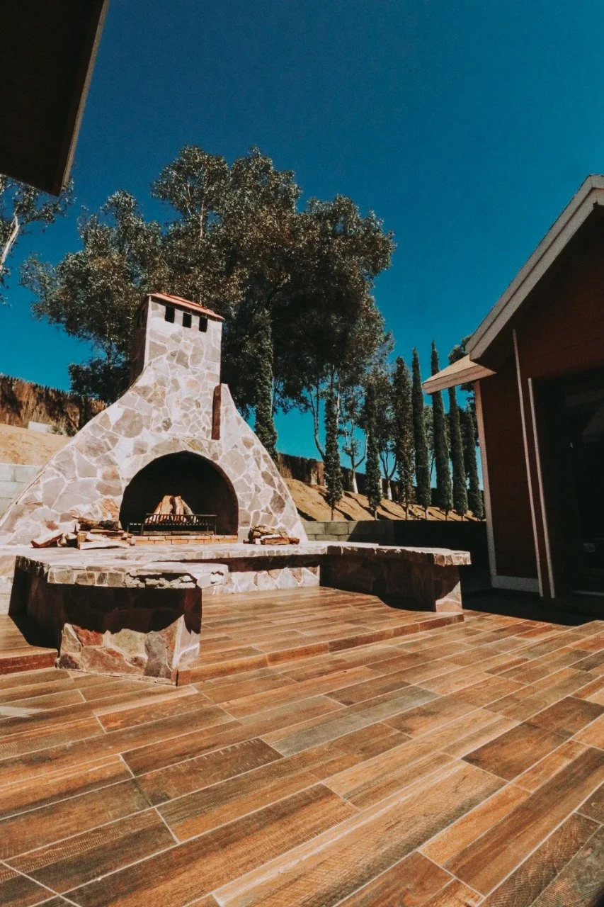 Interior patio with a stone fireplace perfect for smores at Baja Vineyard Lodge.