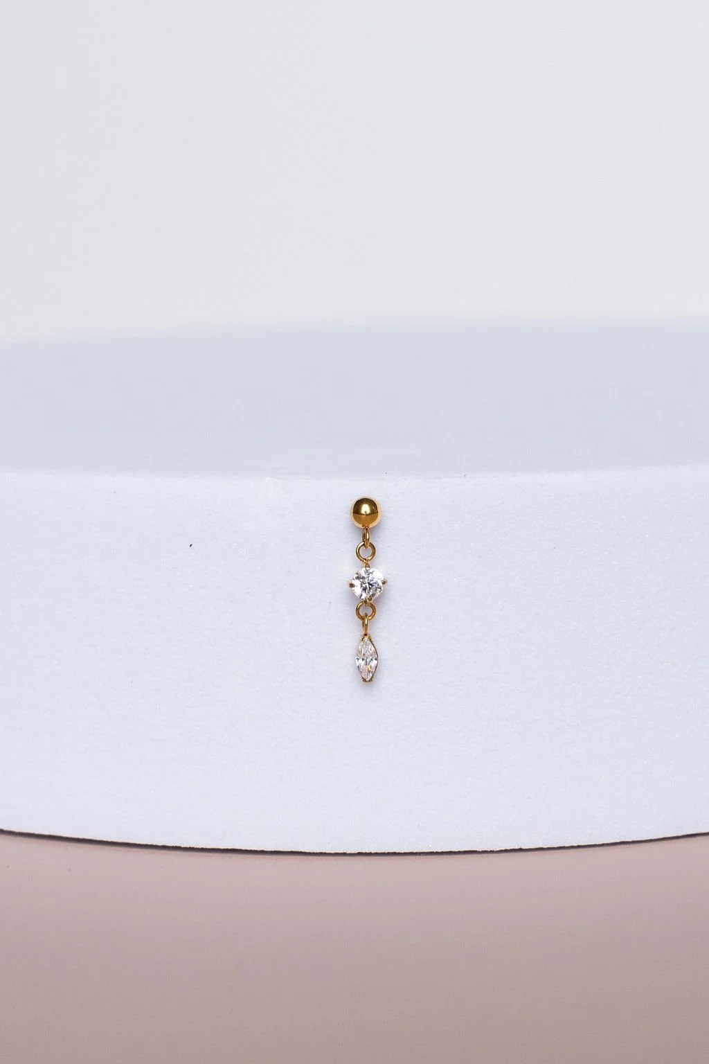 Gold and silver dangling earring with clear gemstones, displayed on a white background.