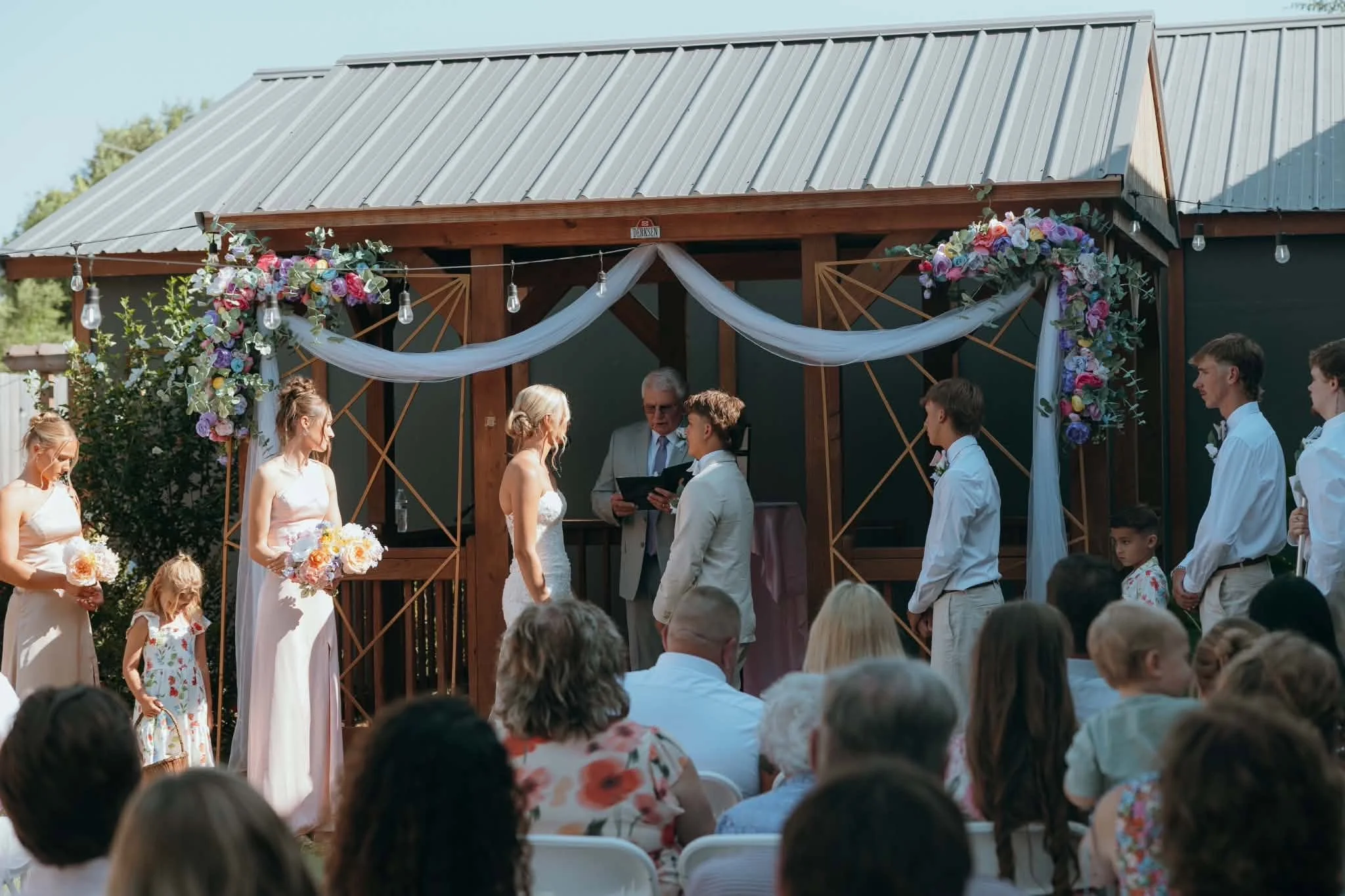 Laurie’s customers, Mariana and Carmen holding hands on a green lawn on their wedding day.