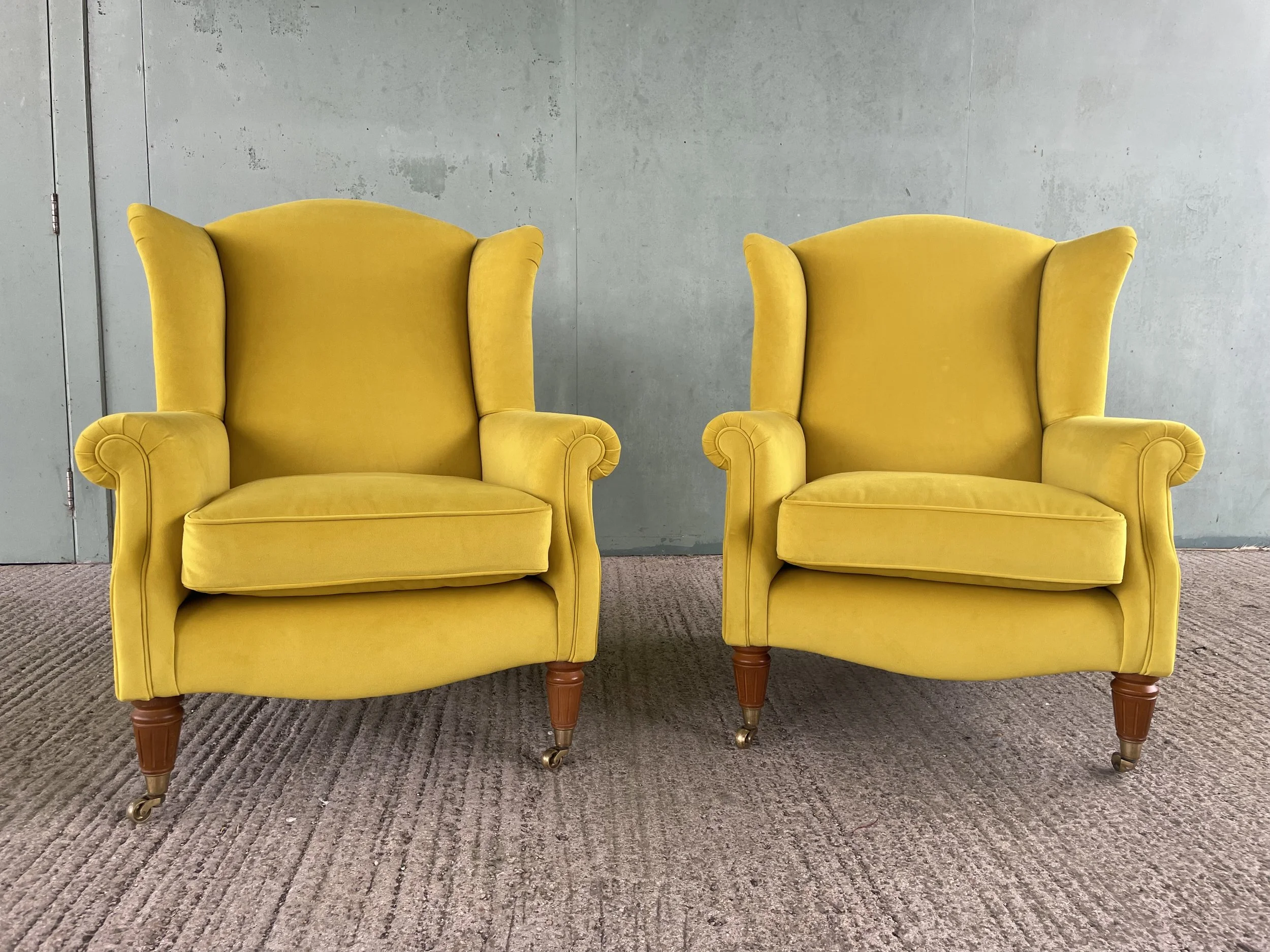 Two matching armchairs in yellow velvet fabric by Linwood Fabrics.