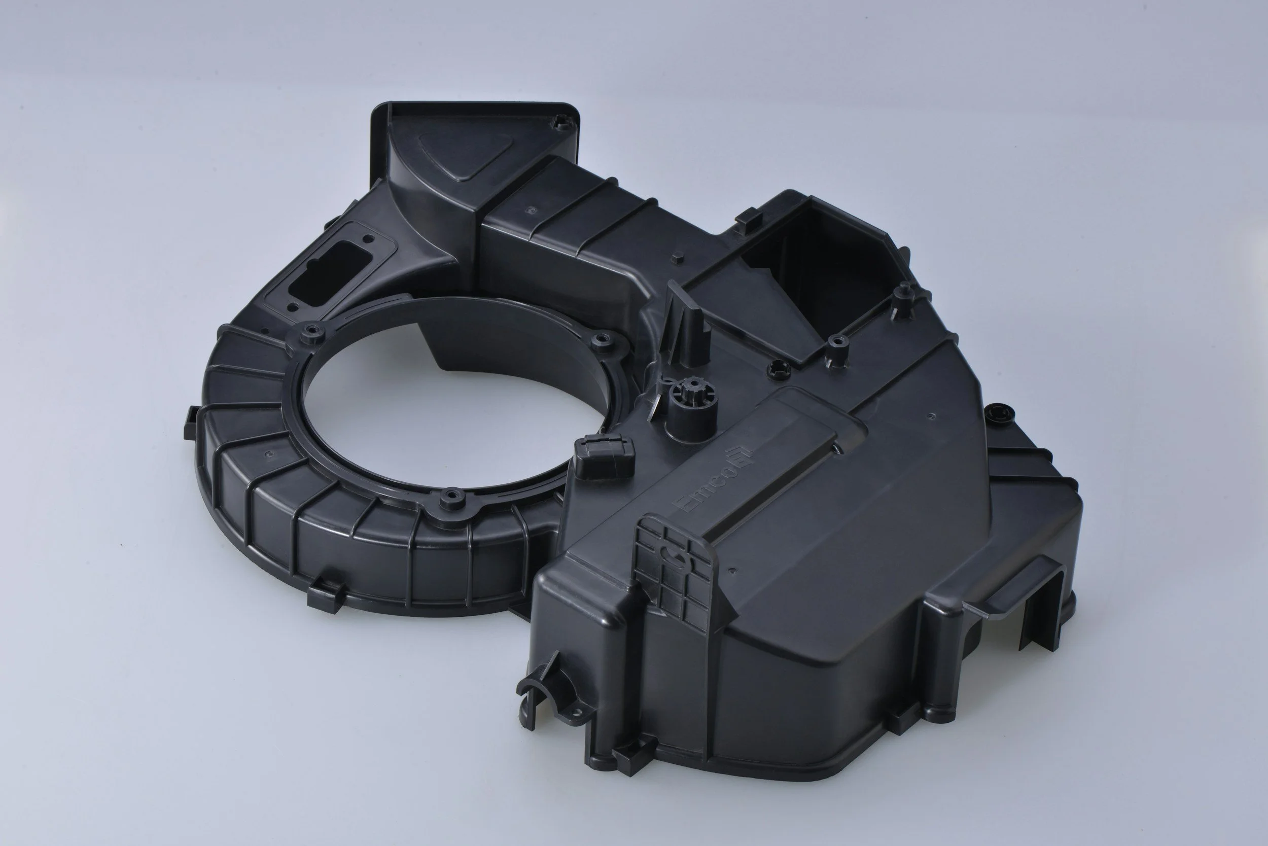 Black molded plastic equipment housing showing ribs, mounting points, and a circular opening