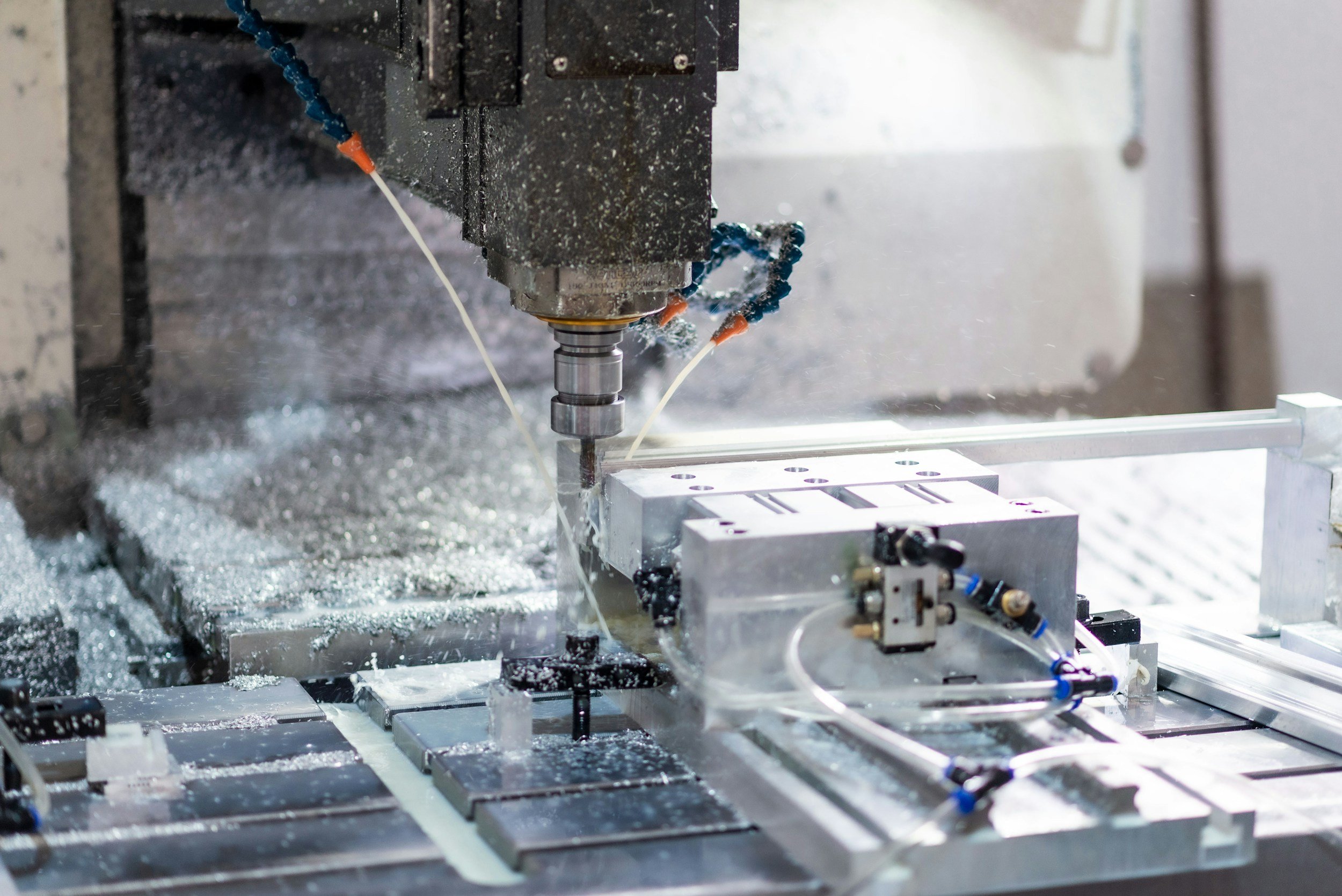 Industrial milling machine machining a metal workpiece with coolant nozzles