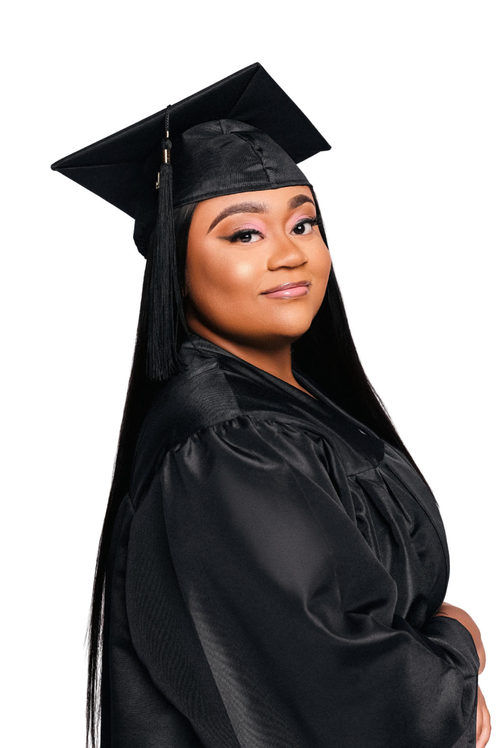 A woman in a black graduation cap and gown, smiling softly, with long black hair and makeup, against a dark background.