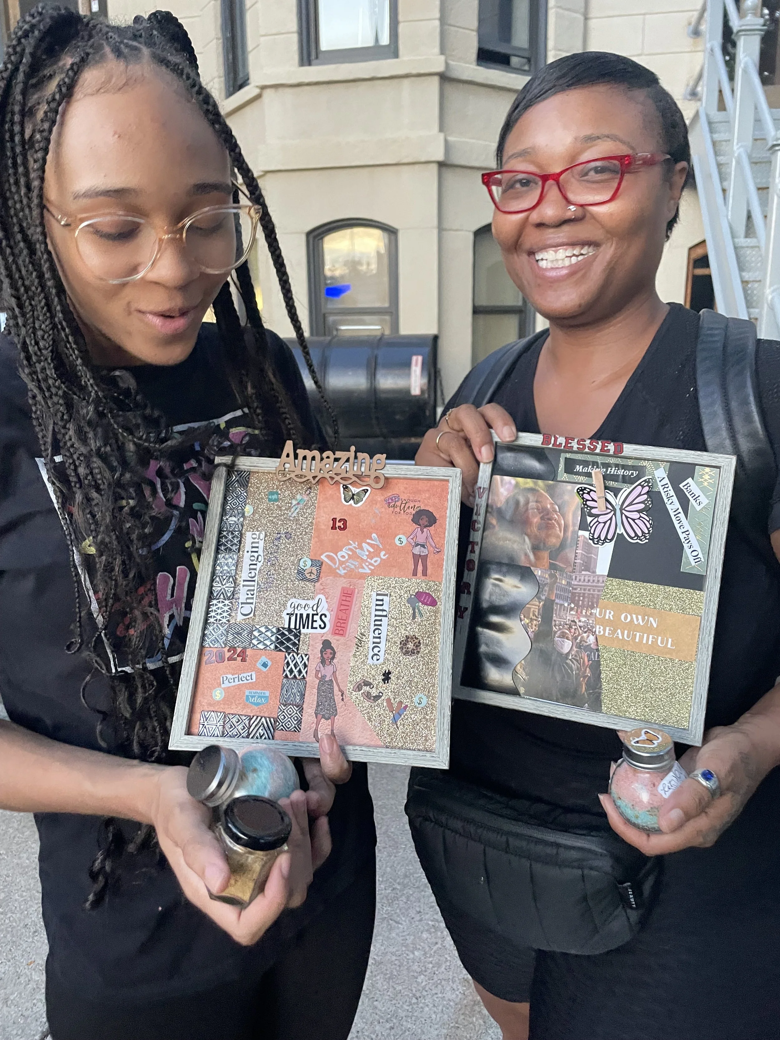 Mother and daughter proudly displaying their completed vision boards during a FAM Entertainment Theater Company creative experience.