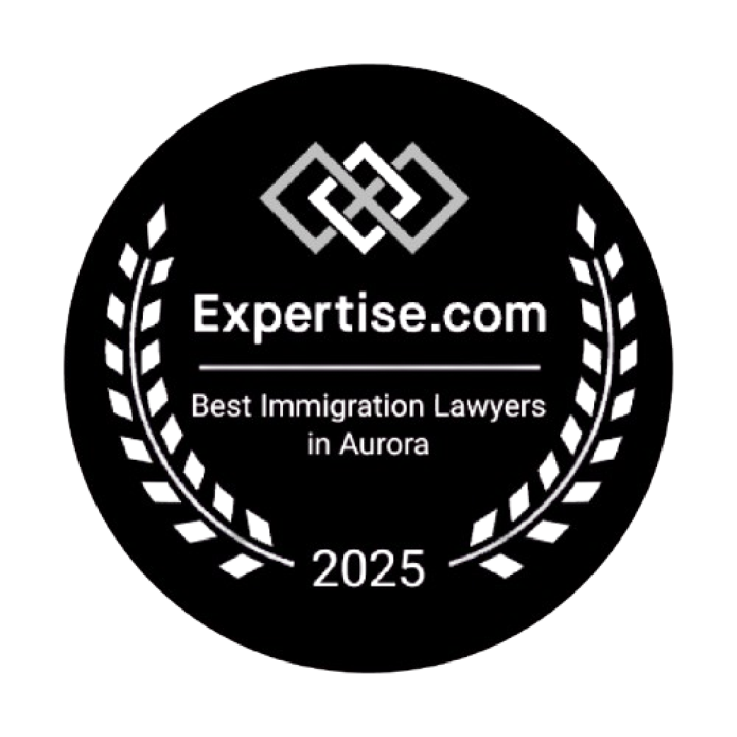 Black circular badge featuring a silver decorative design at the top, white text in the center that reads 'Expertise.com,' a mention of 'Best Immigration Lawyers in Aurora,' and the year '2025' at the bottom, surrounded by a white laurel wreath.