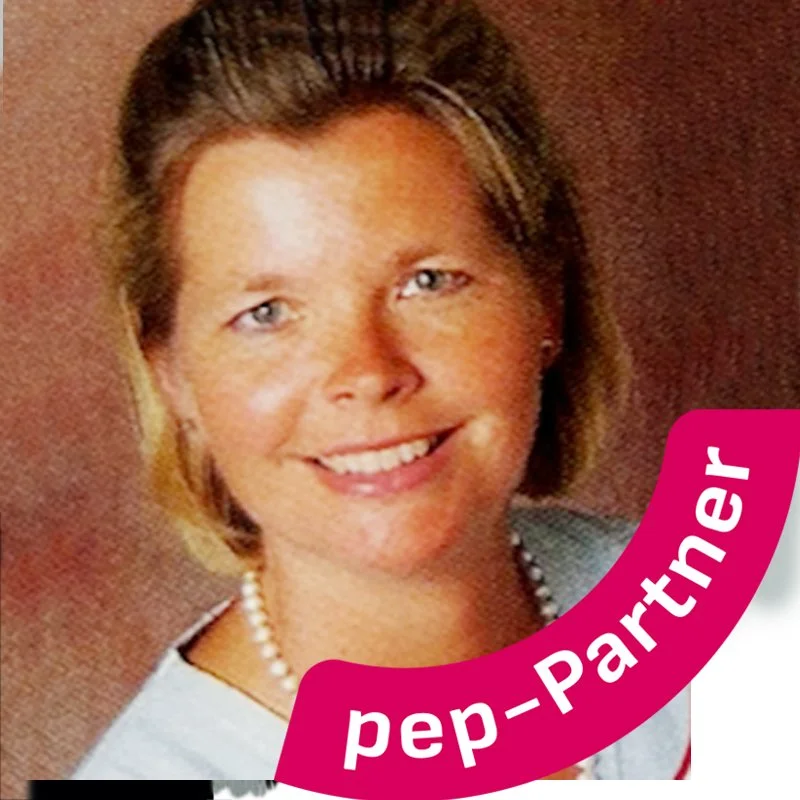 Ein Porträtfoto einer lachenden Frau mit kurzer, blond-brauner Frisur, weißen Zähnen, Perlenkette, und rosa Schriftzug mit dem Wort 'pep-Partner' im Vordergrund.