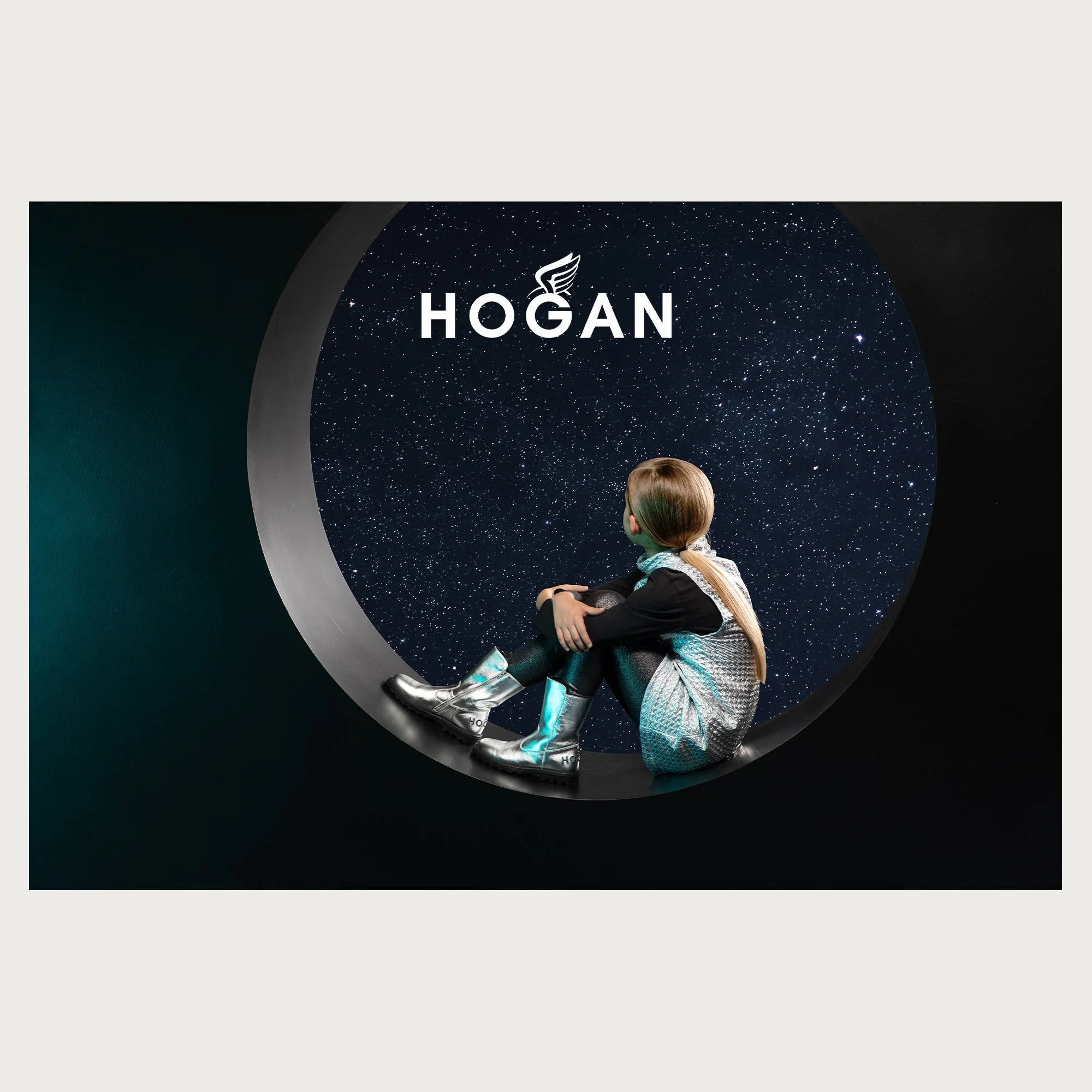 Silver boots and quilted dress, girl sitting on a crescent moon against a starry sky — Hogan campaign.