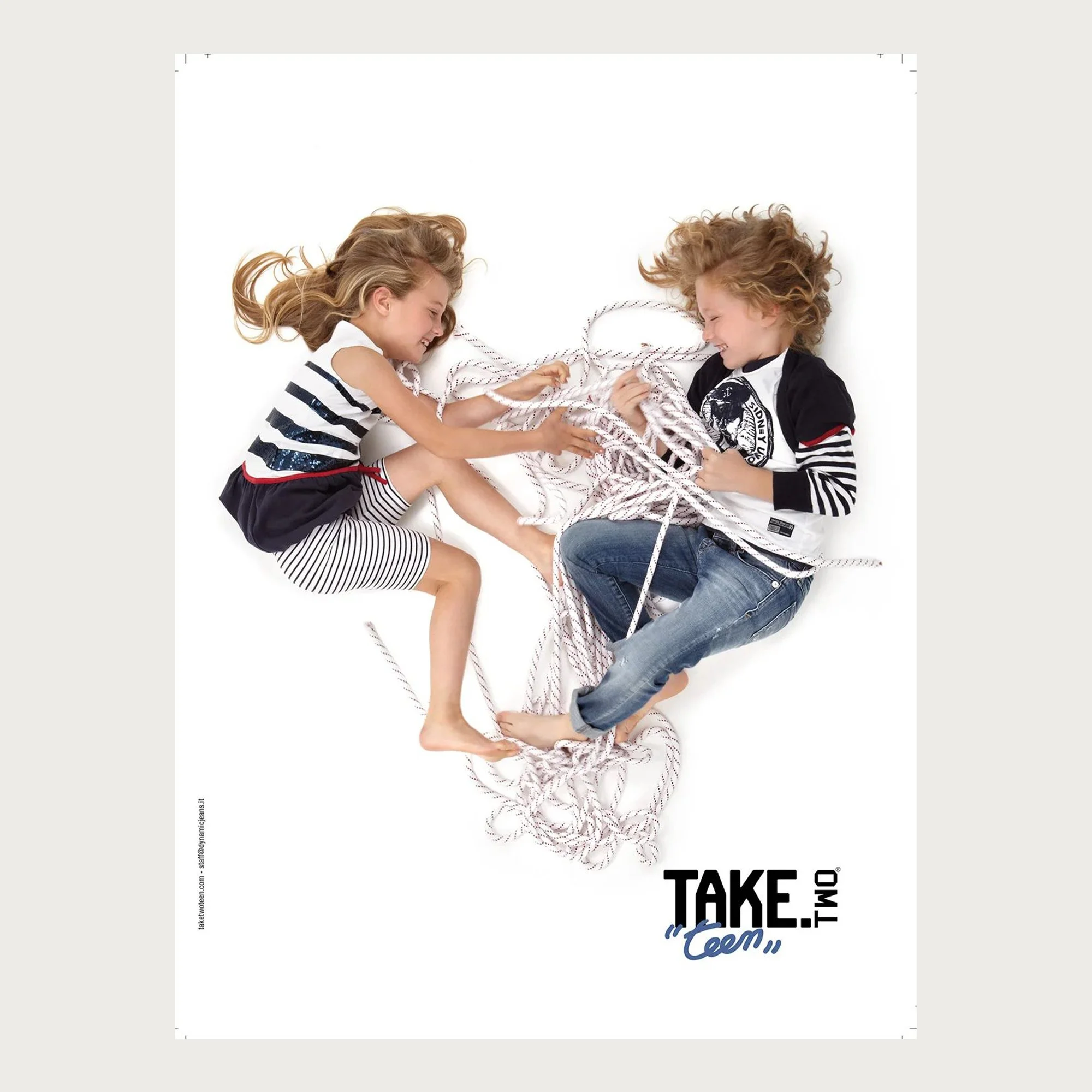 Striped jersey and denim, two children lying tangled in white rope, seen from above — Take Two Teen campaign.