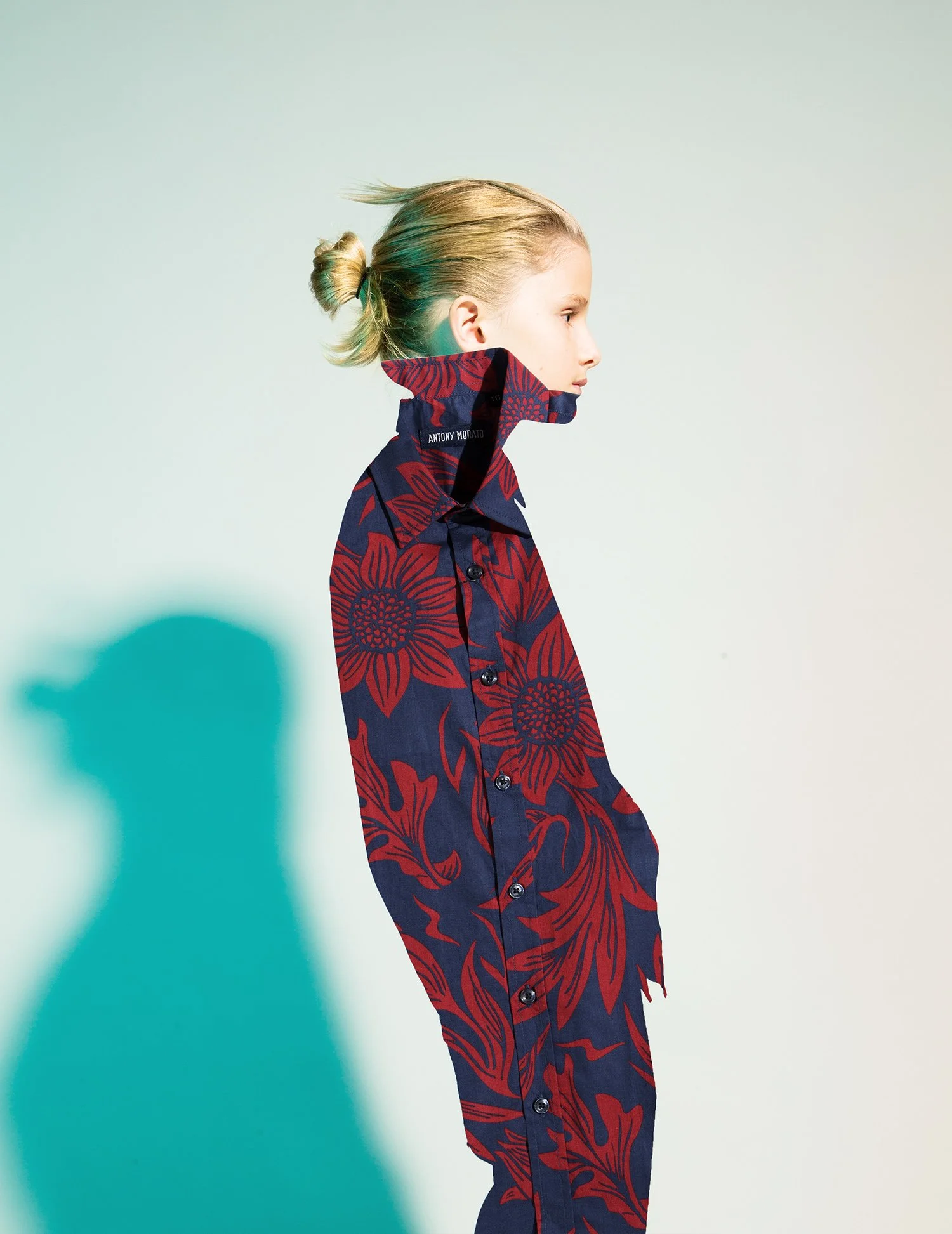 Style Piccoli editorial — floral print suit and its shadow on a pale teal wall.