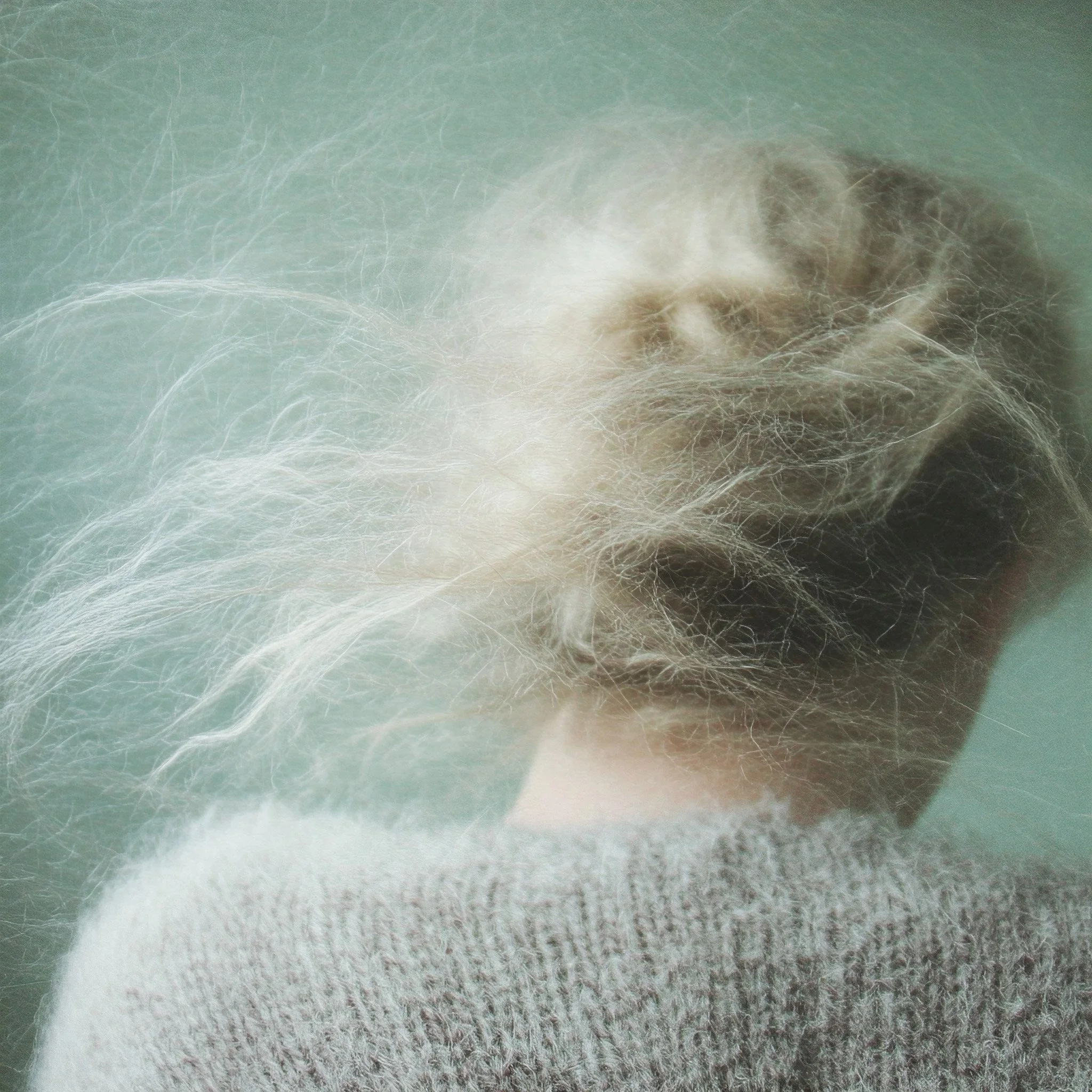 Woman's windswept hair and grey mohair sweater, close-up. AI-generated image.