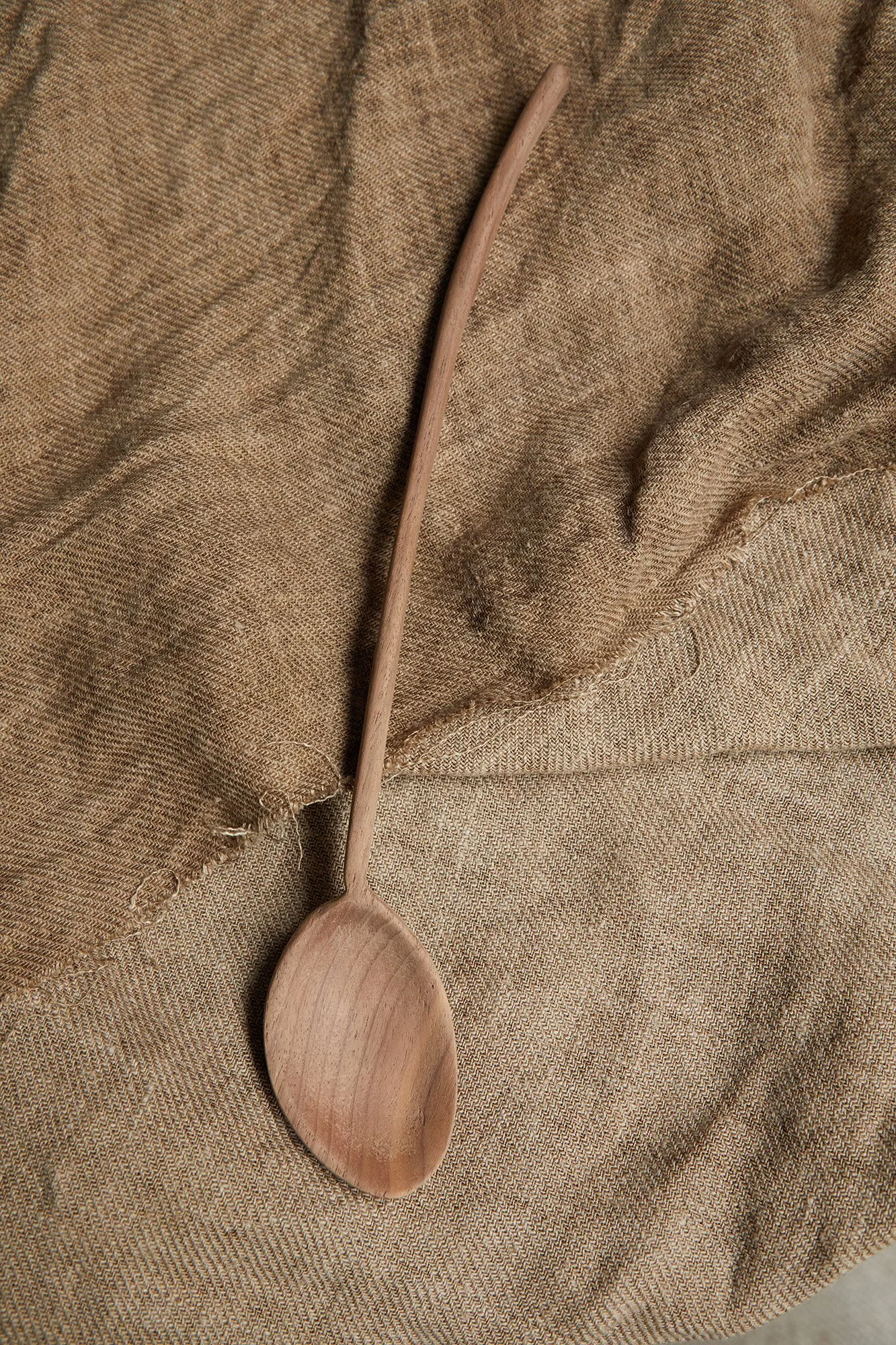 Carved wooden spoon on rough brown linen