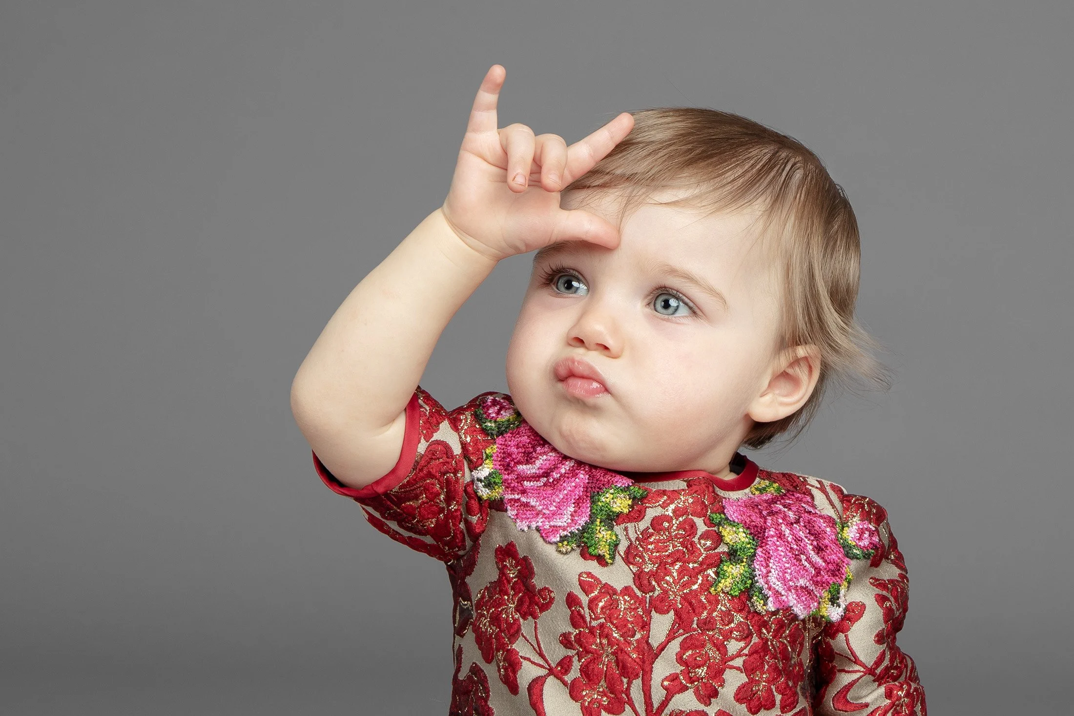 Dolce & Gabbana — baby in red brocade making the rock sign.