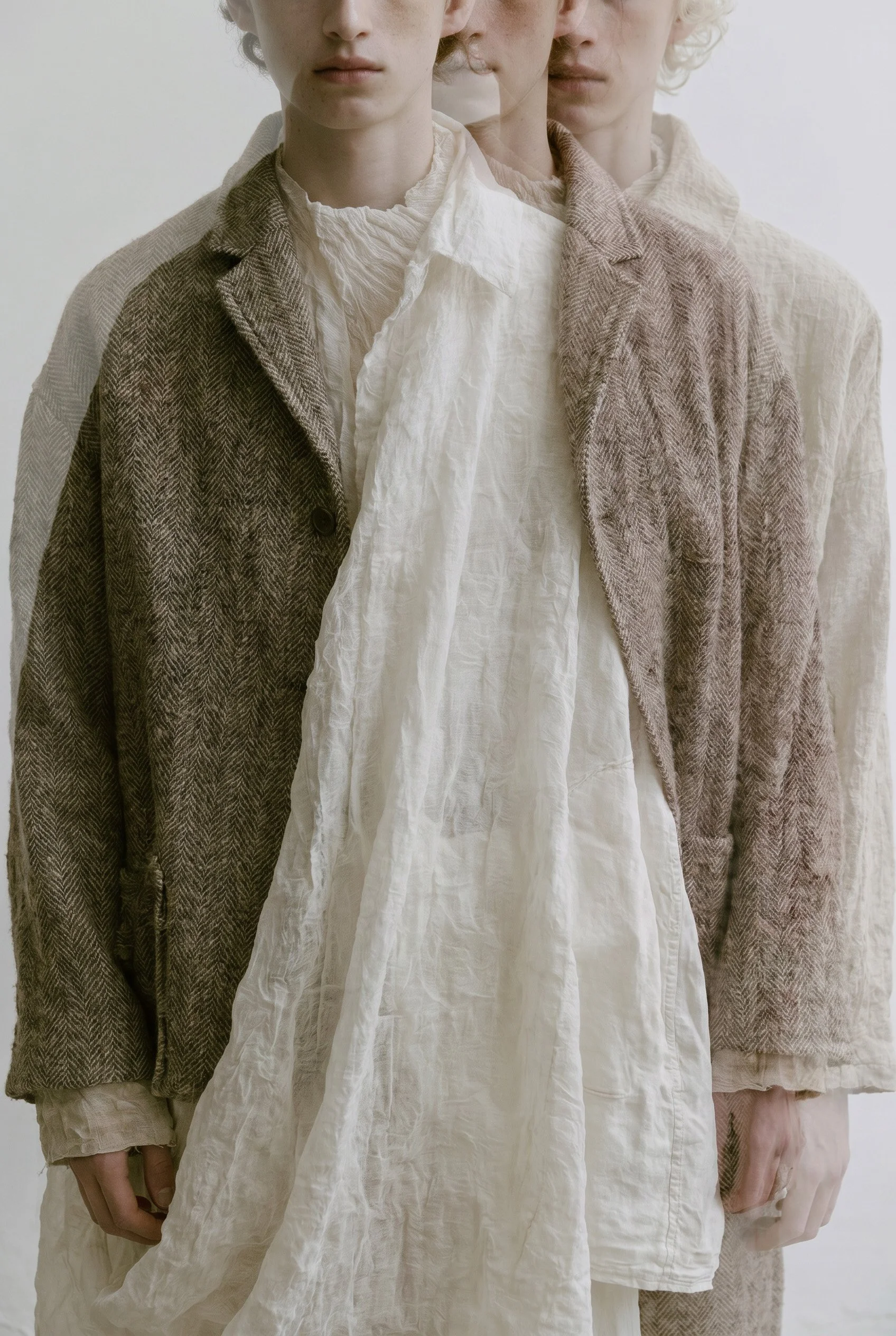 Layered linen and wool coats, three figures. AI-generated image.