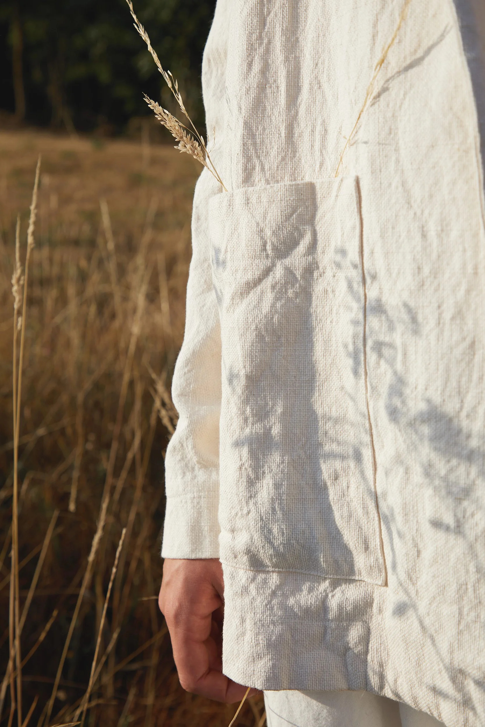 Natural linen jacket with dry grass in a golden field