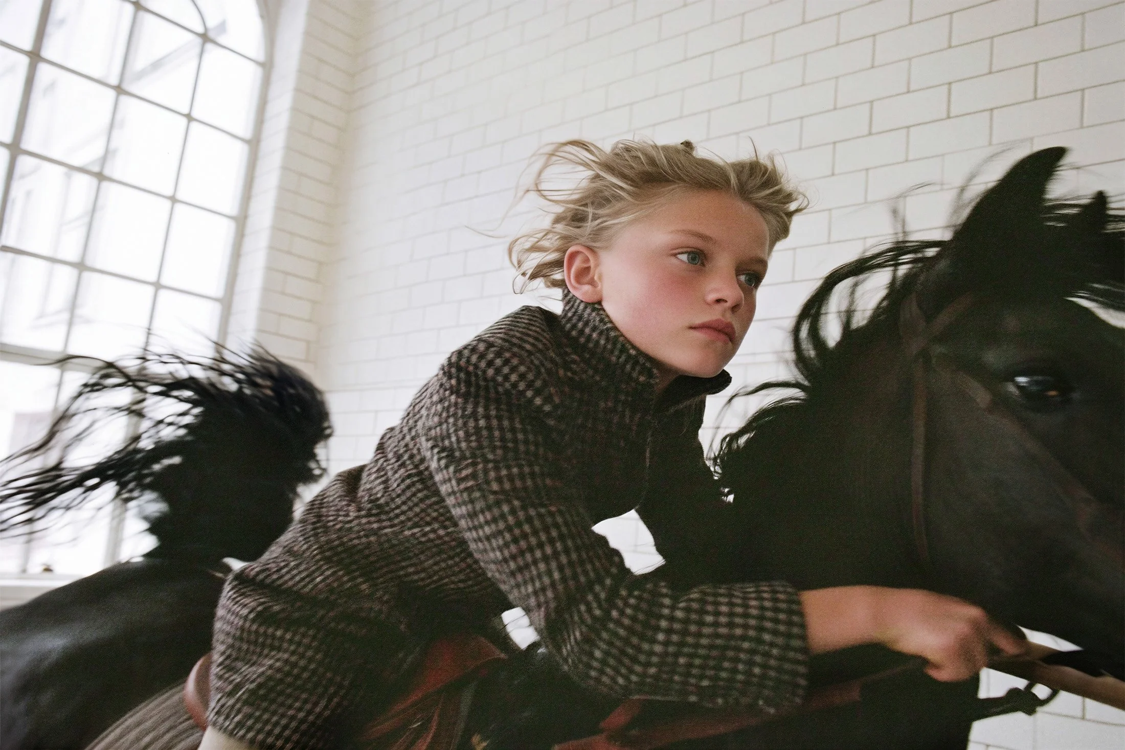 Child riding a black rocking horse through a white studio room. AI-generated image.