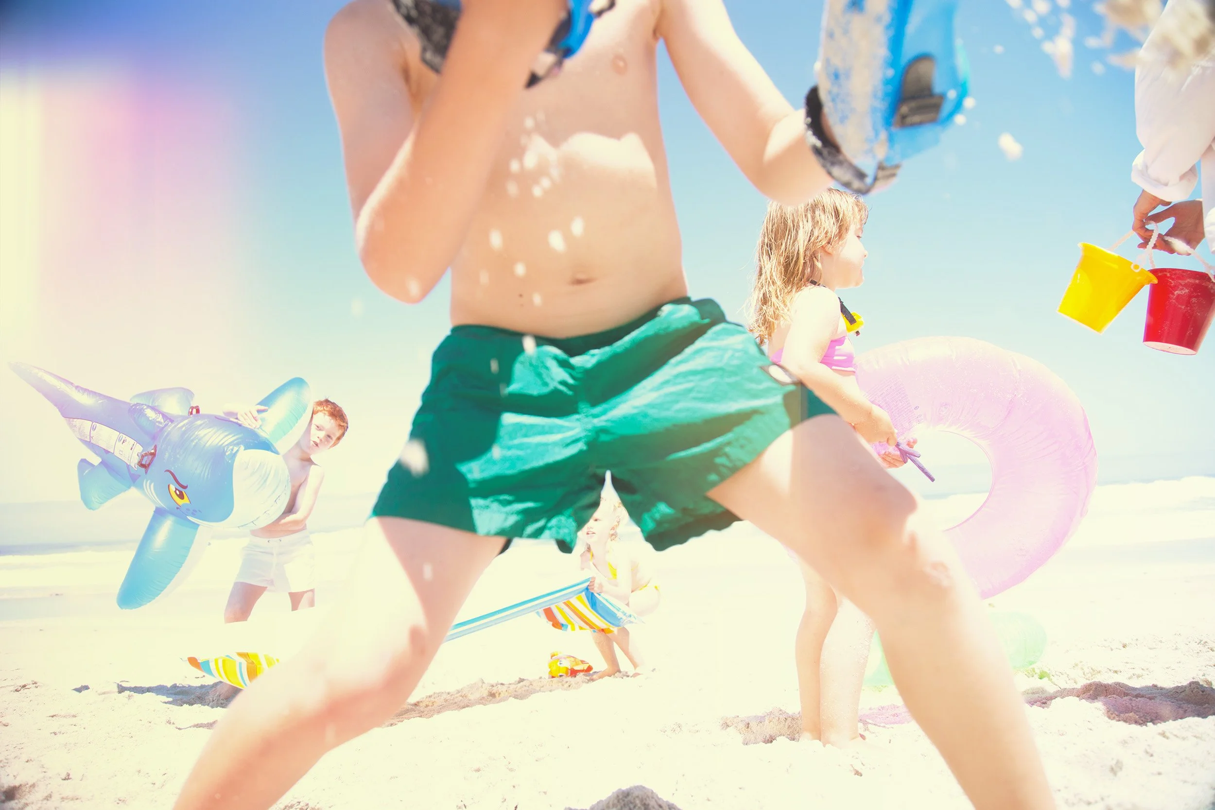 Style Piccoli editorial - children on the beach with inflatable toys, summer light.