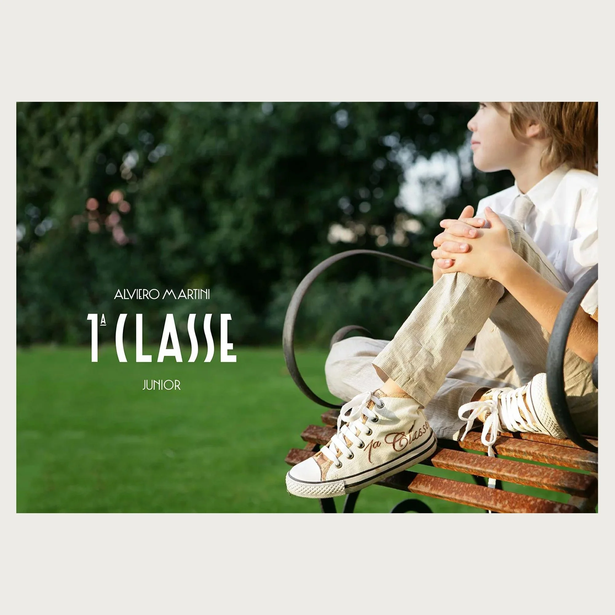 Canvas high-tops and linen shirt, boy on an iron bench against a lawn — Alviero Martini 1ª Classe Junior campaign.