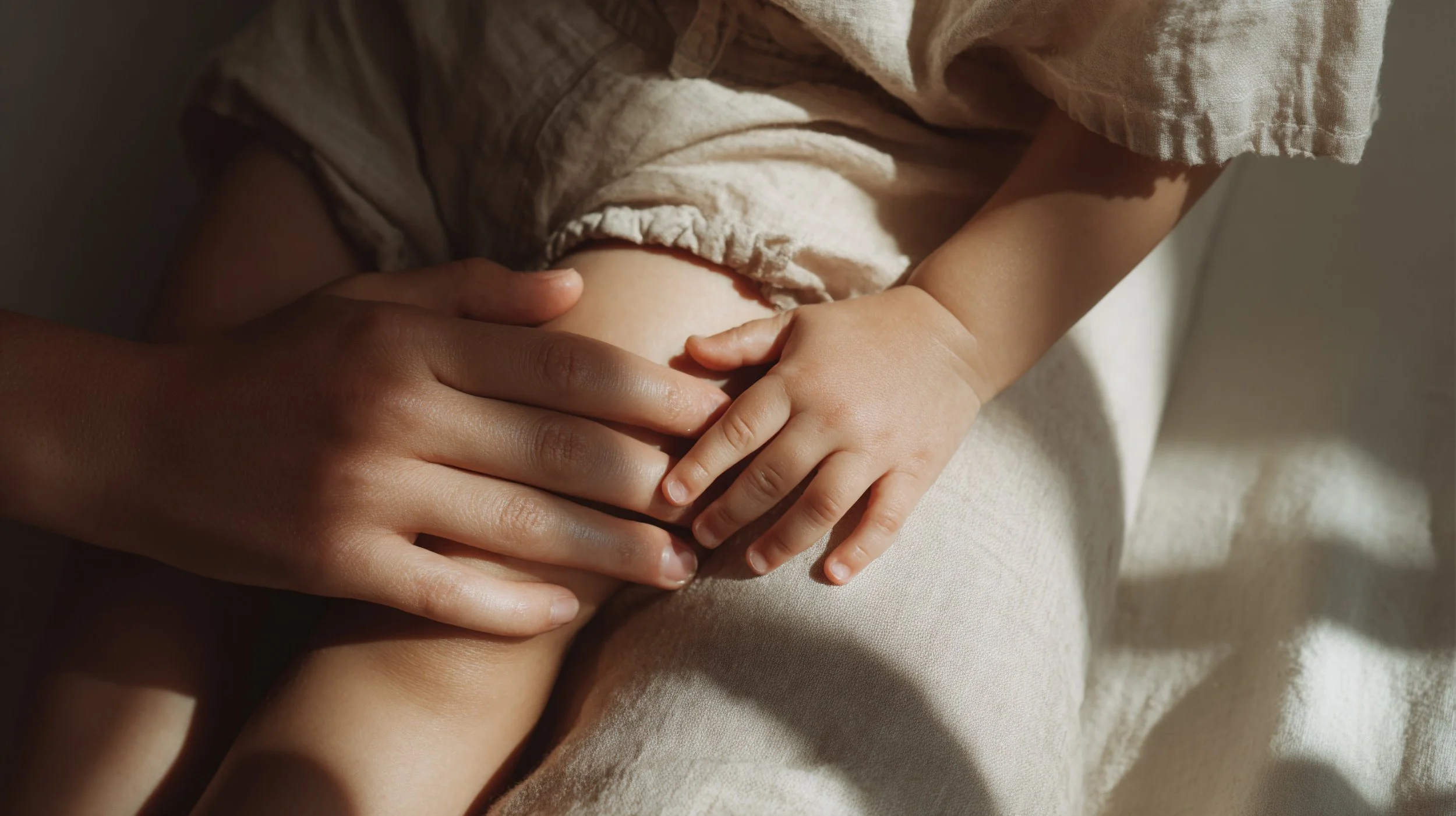 Mother and baby hands resting on soft linen in natural light. AI-generated image.