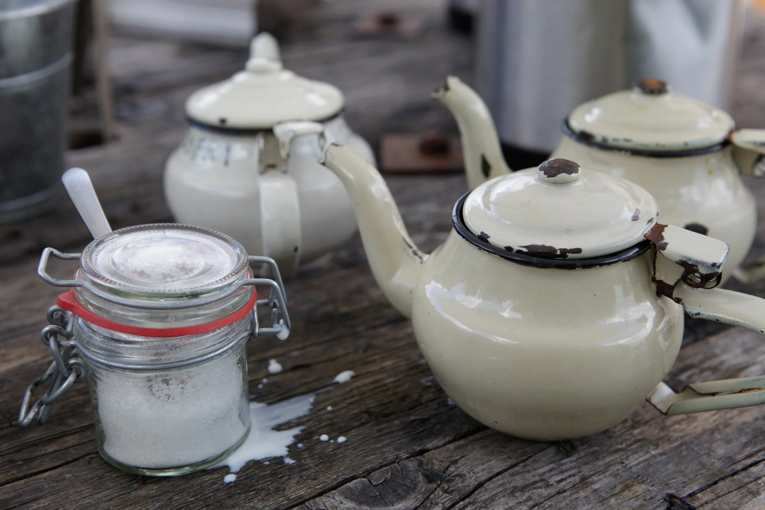 Enamel teapot and sugar jar on a rustic wooden table