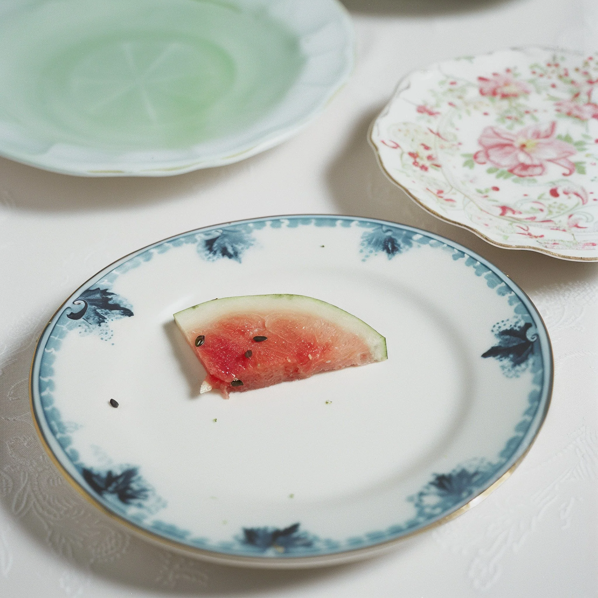 Watermelon slice on vintage floral ceramic plates. AI-generated image.