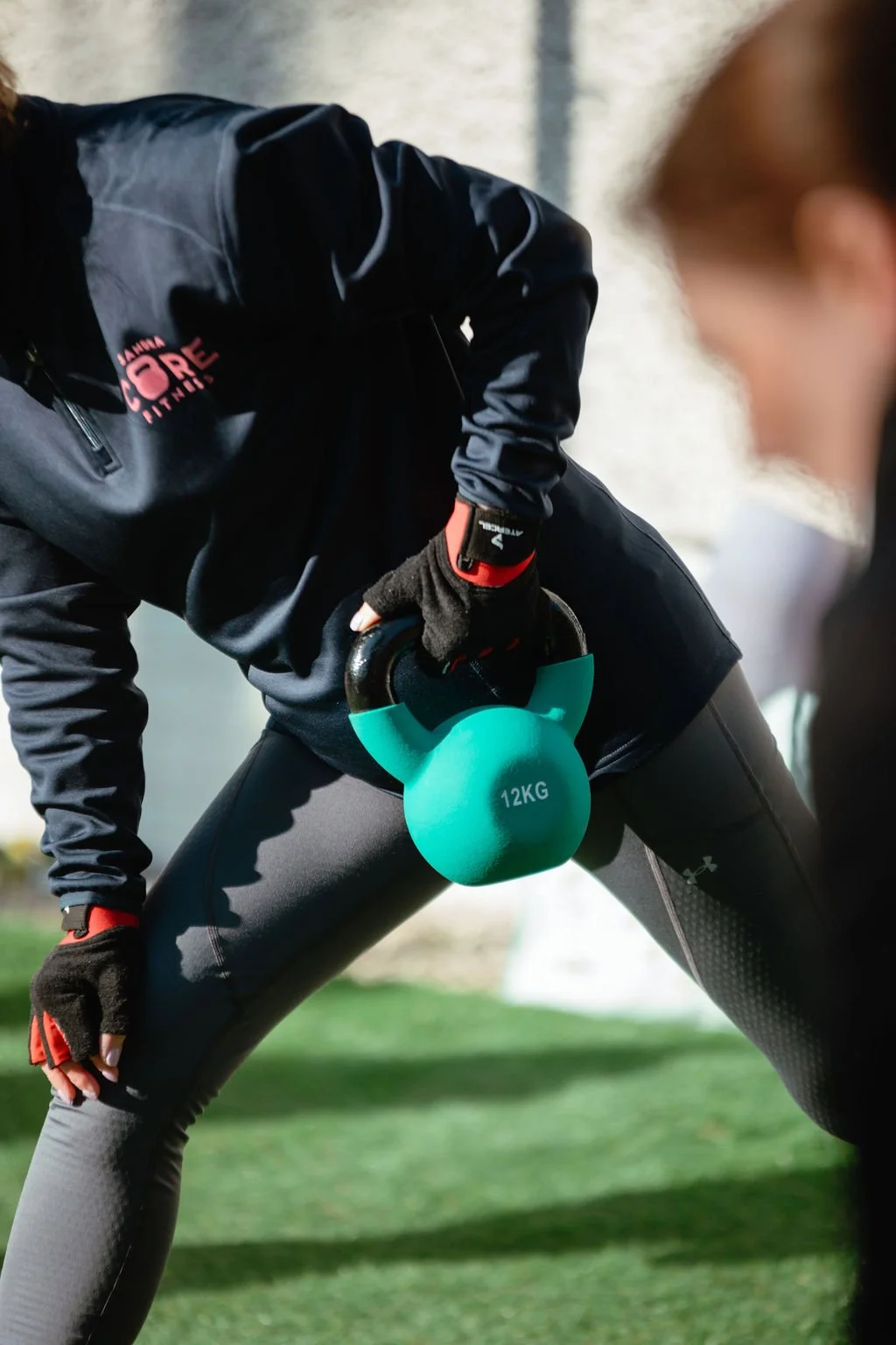 Client performing a kettlebell workout outdoors at Holmes Core Fitness