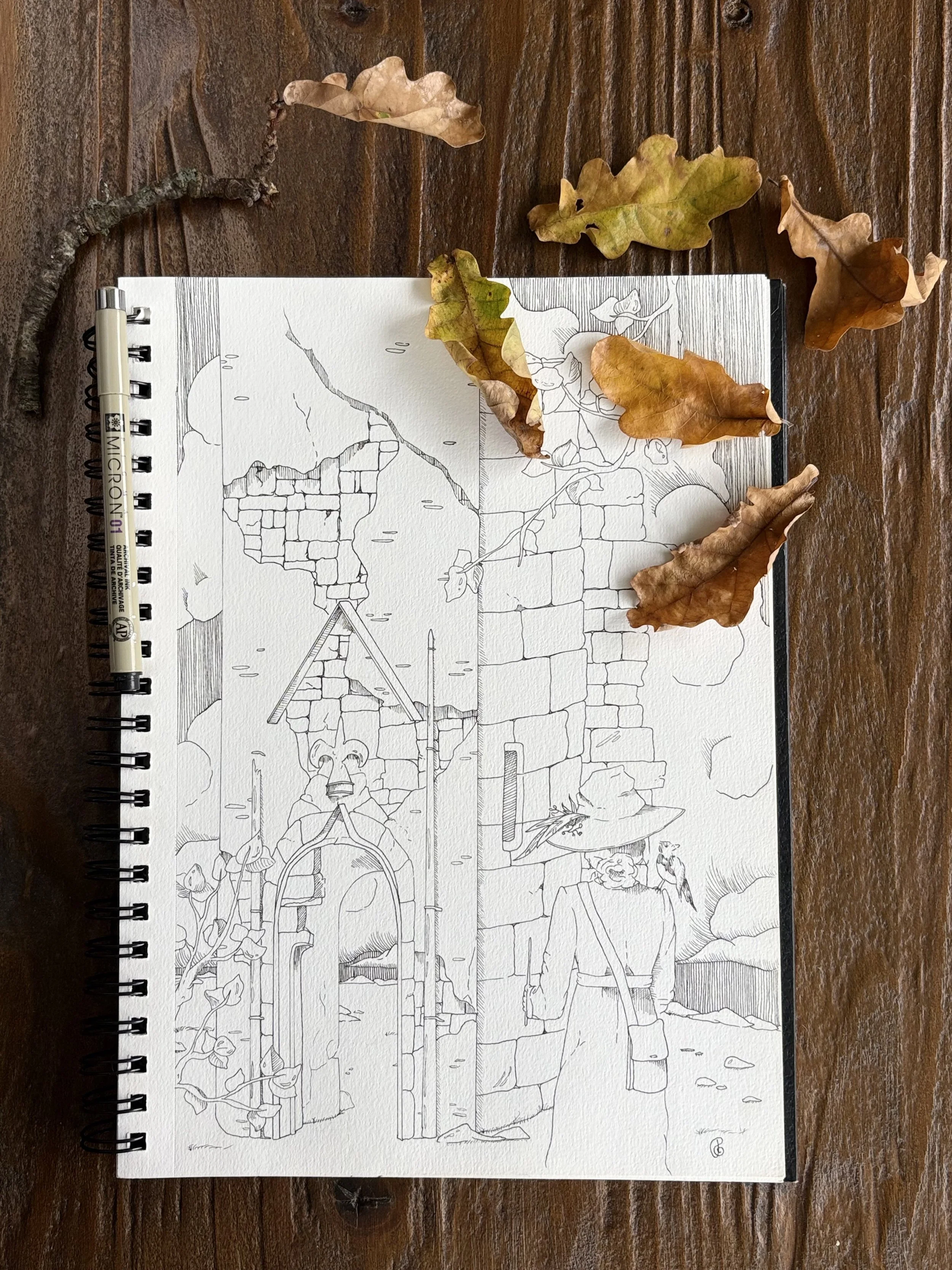 An artwork in line art of a witch standing with her back against you looking at a ruin of a tower. The art is on a spiral-bound notebook next to dried leaves on a wooden surface.