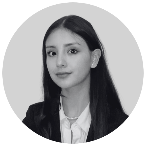 Black and white portrait of a young woman with long dark hair, wearing a blazer, white shirt, and pearl necklace.