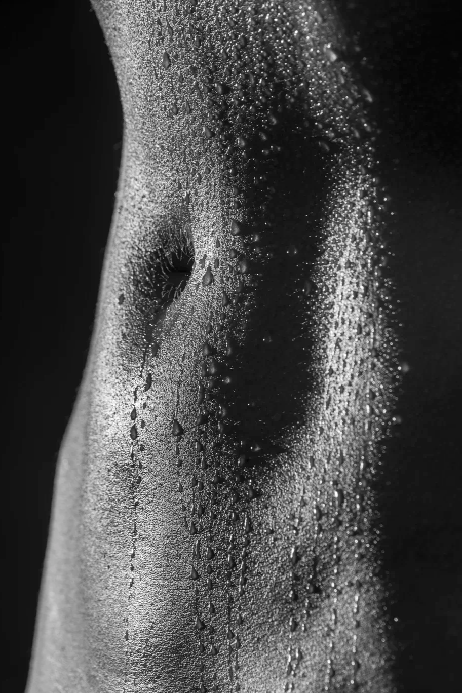 Close-up of a foggy, water droplets-covered surface with a human silhouette in the background.