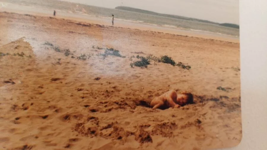 Deirdre Burton as a child playing on the sand