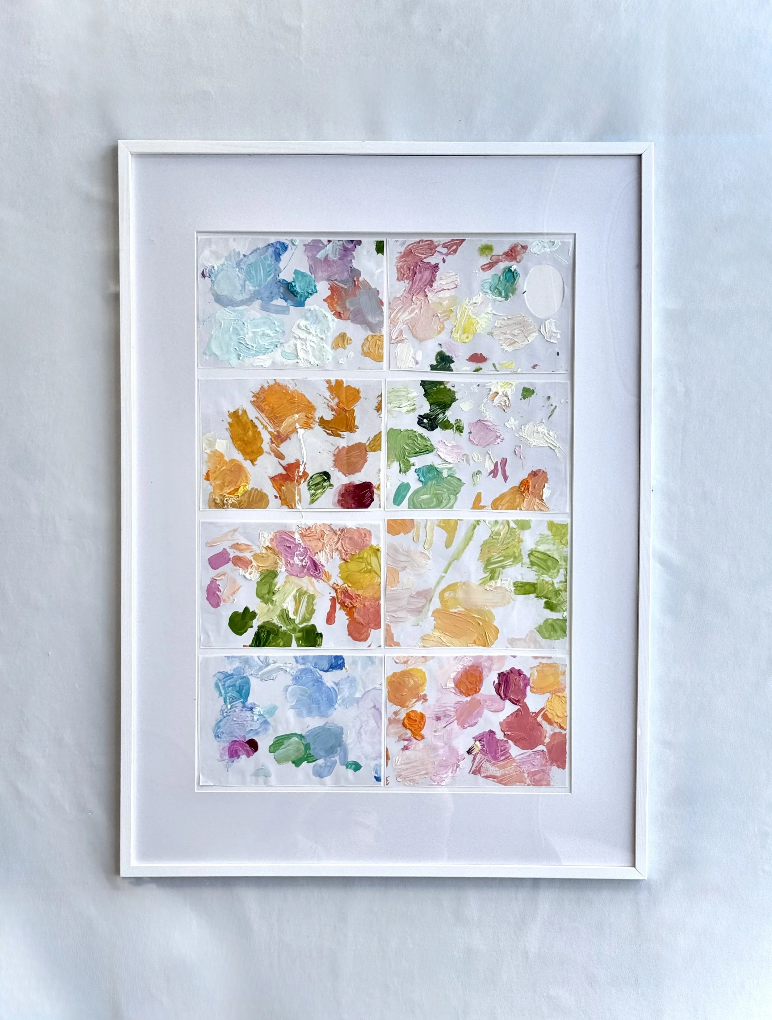 A white framed artwork with a grid of nine sections, each filled with colorful paint swatches on a white background.