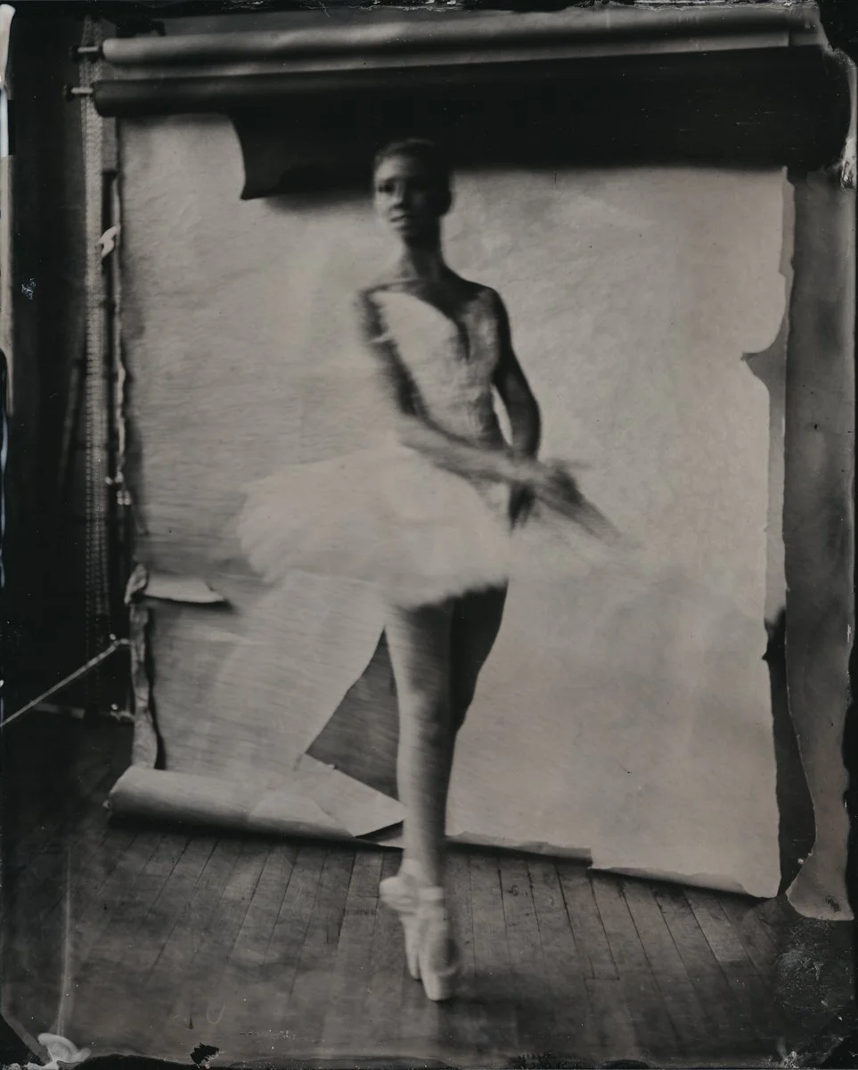 A ballet dancer in a tutu practicing in front of a backdrop, with a slightly blurred and vintage appearance.