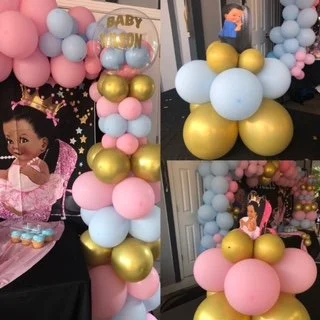 Decorative balloon arrangement with pastel pink, blue, white, and gold balloons, including a DIY labor and delivery banner, at a baby shower.