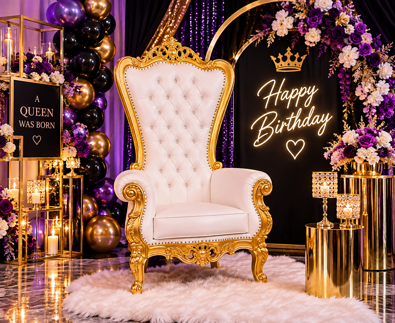 An elegant birthday celebration setup featuring a white and gold throne-like chair on a fluffy white rug, surrounded by purple and white flowers, gold and black balloons, and candles. A neon sign reads "Happy Birthday" with a crown graphic, and a blackboard sign says "A Queen Was Born" with a heart.
