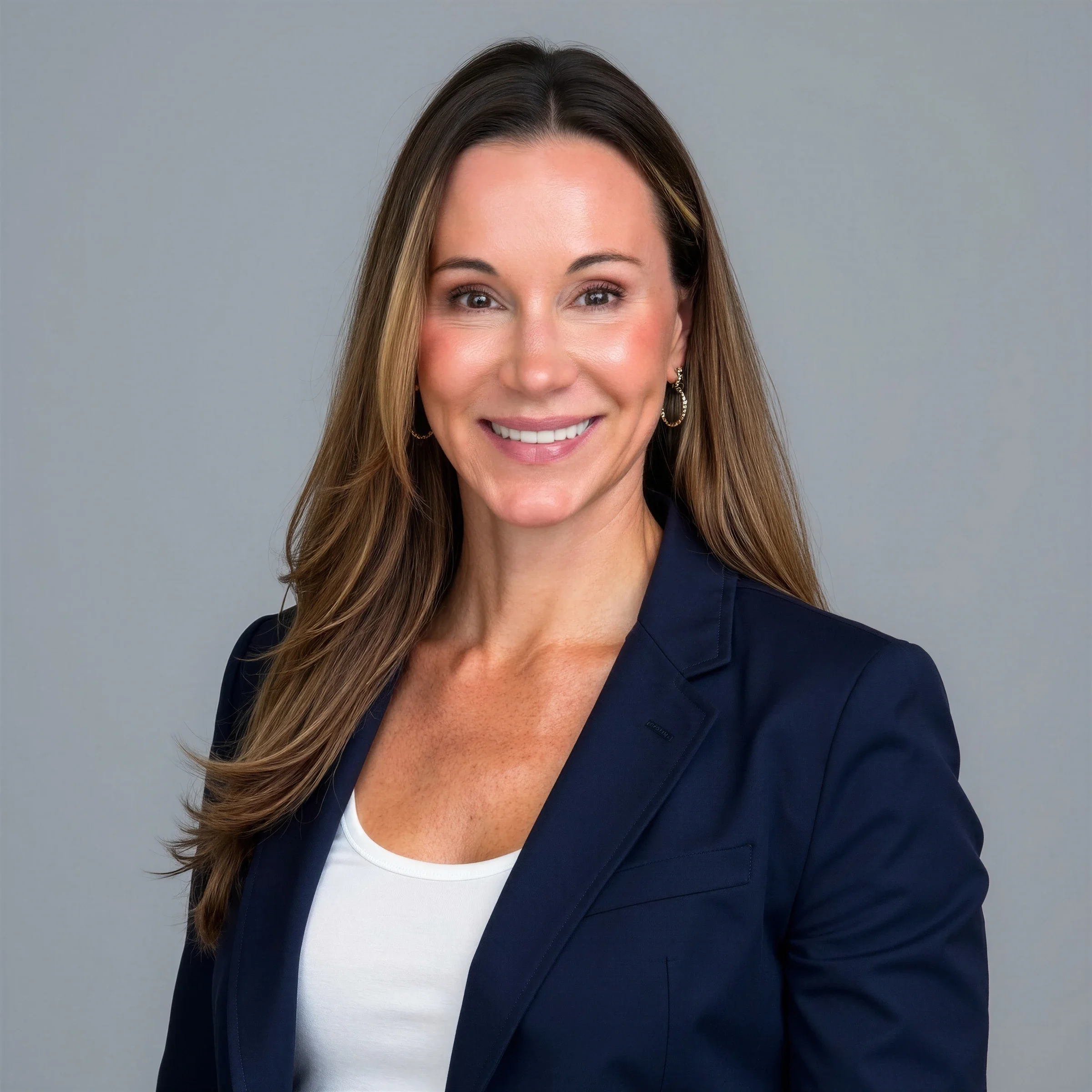Lauren Elias, beauty and wellness executive, wearing a navy blazer in a professional studio portrait