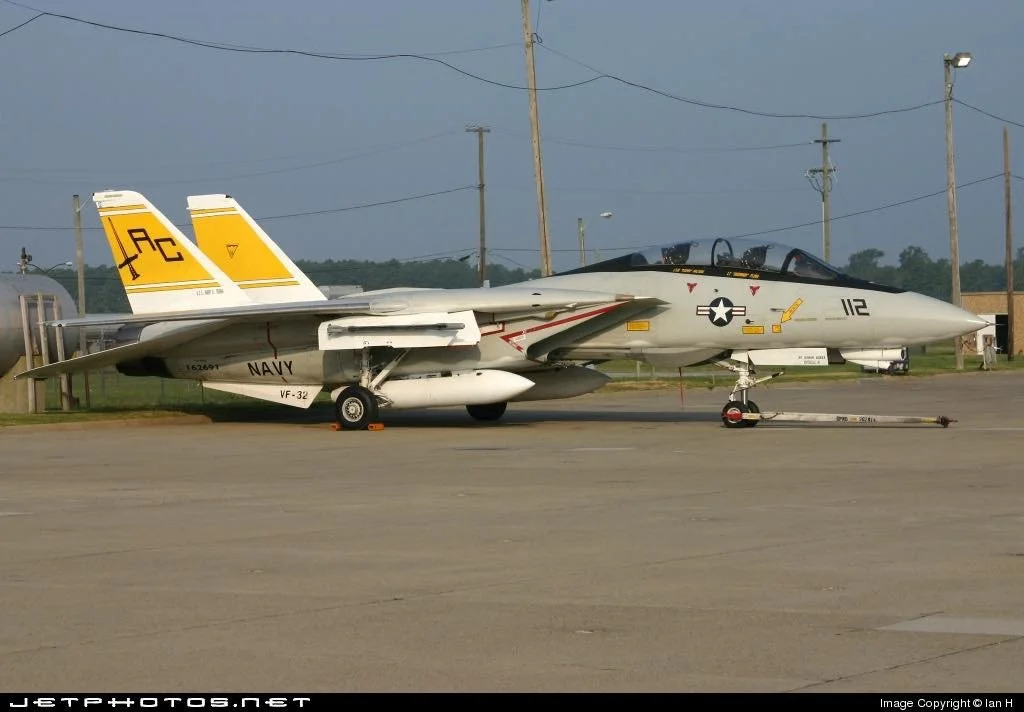 F-14B Tomcat aircraft 112 on the flight line, bearing the names of Commander TJ Flora and Scott Walters.