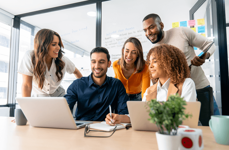 Campaign image of a team gathered around a laptop