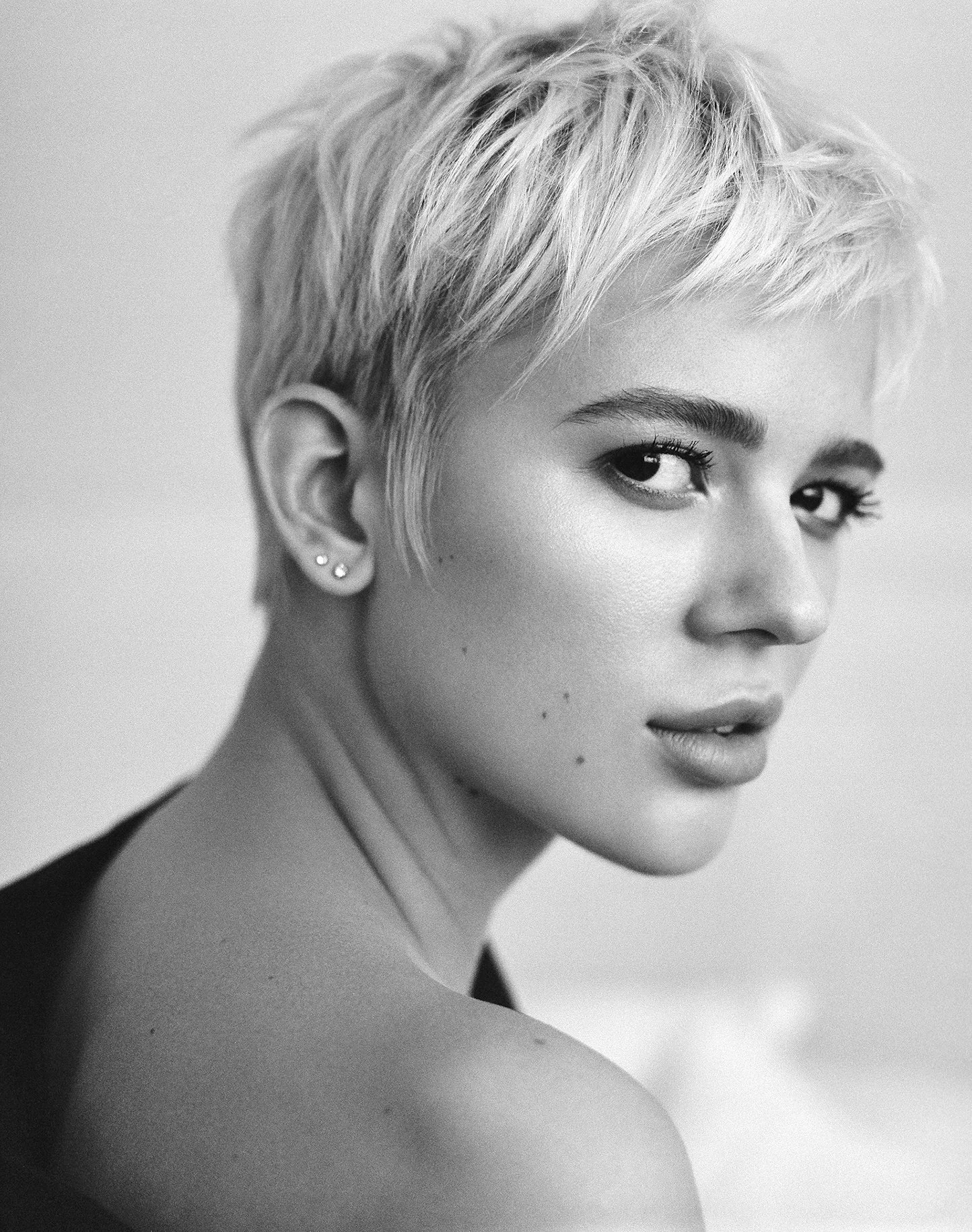Black-and-white close portrait of a woman with short, textured blonde hair.