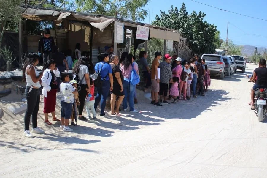 Families waiting for a meal in Caribe Bajo, from the September 2026 ministry newsletter.