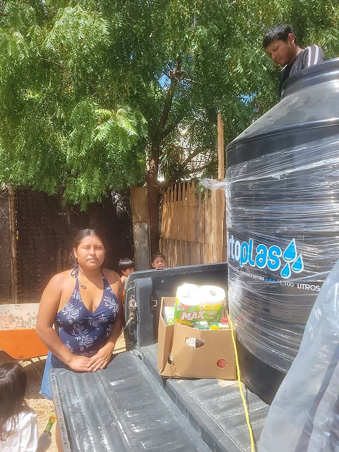Yulisa with the water tank and groceries provided through Donation Connect.