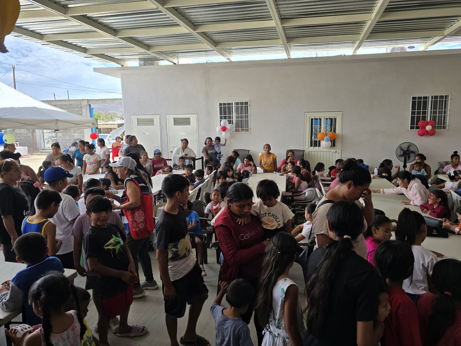 Familias y niños reunidos en una celebración del centro comunitario.