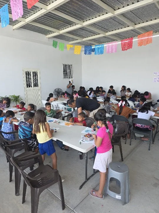 Children and volunteers gathered around activity tables at the community center in Cabo San Lucas.