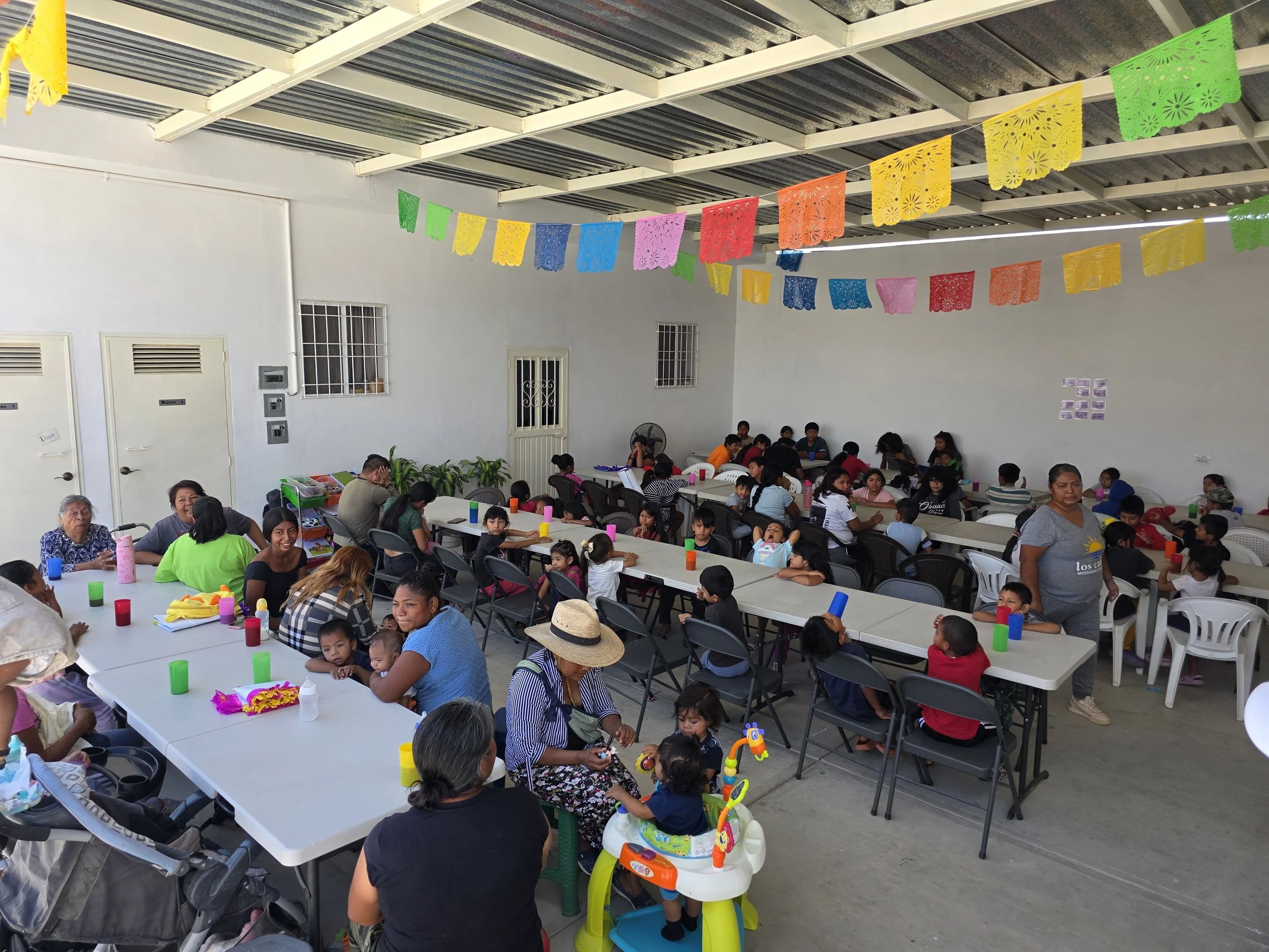 Families gathered around tables at the Los Cabos Missions for Christ Community Center.