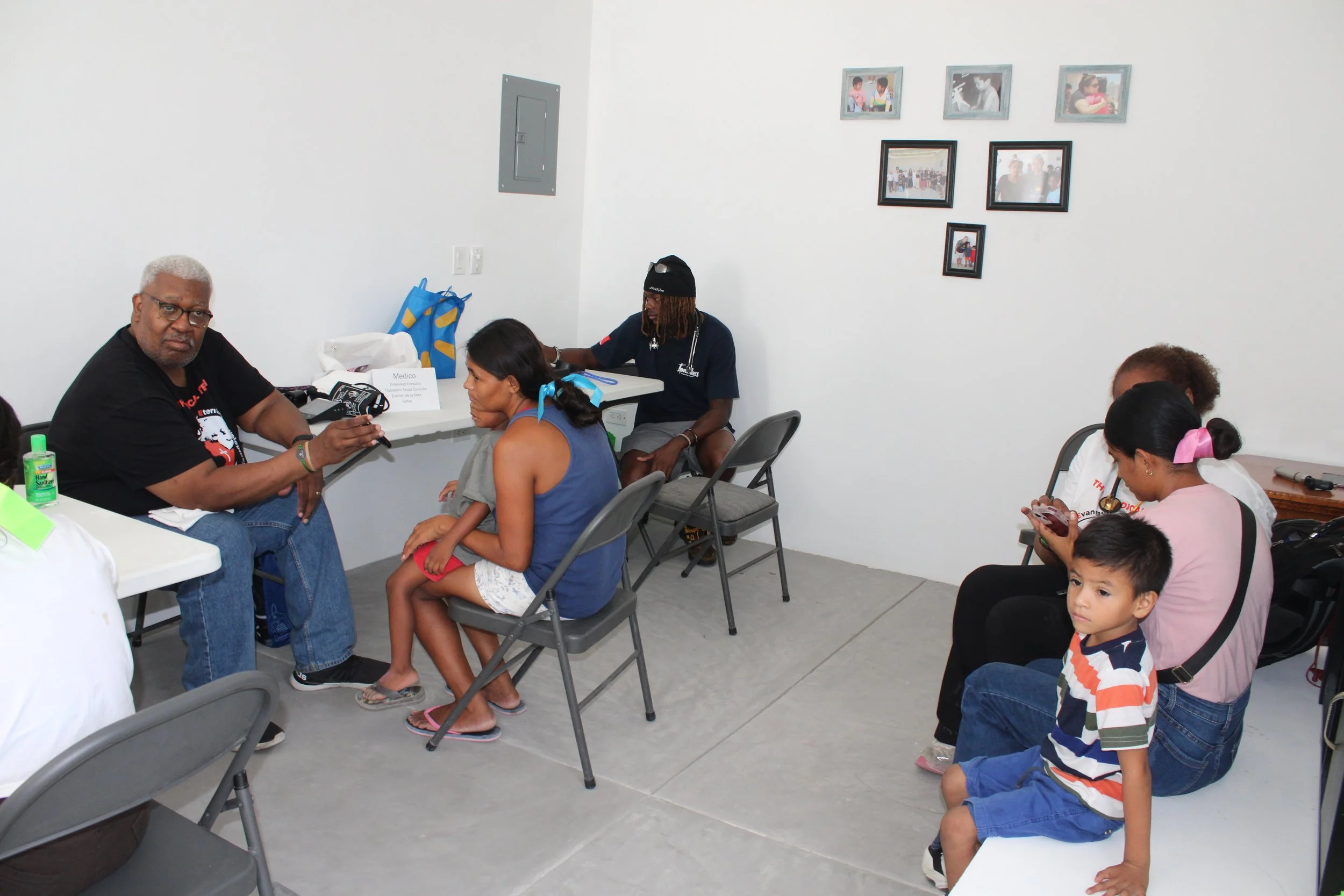 Families meeting with volunteers at tables during a community health outreach.