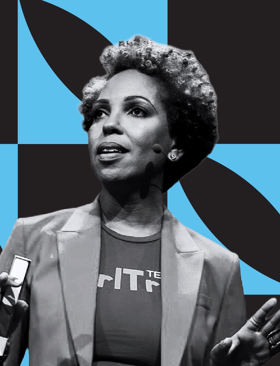 A black and white photo of a woman speaking, wearing a blazer and a T-shirt with partially visible text, against a blue and black geometric background.