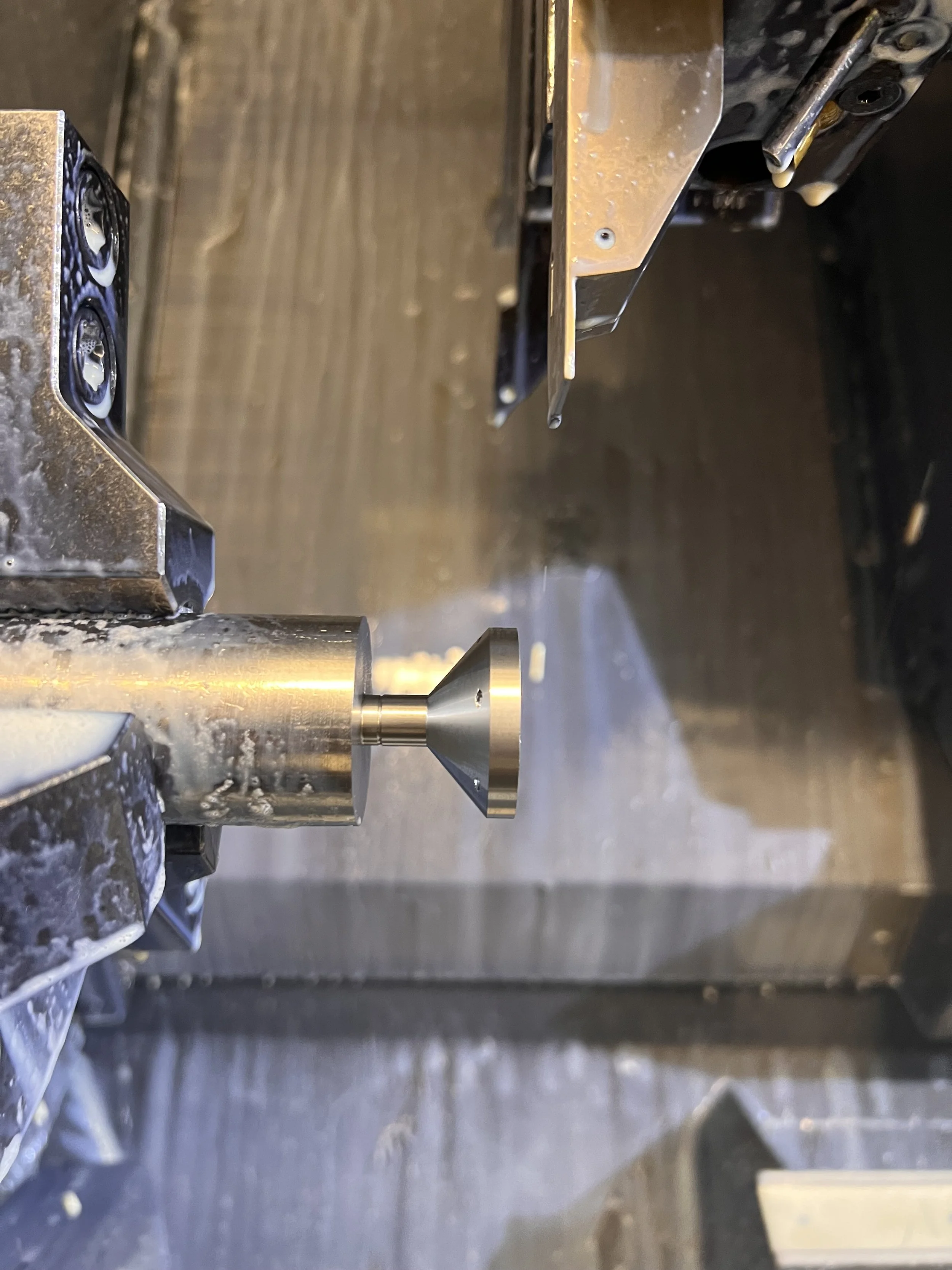 Close-up of metallic mechanical components, possibly part of a machine or engine, with some oil or lubricant visible.
