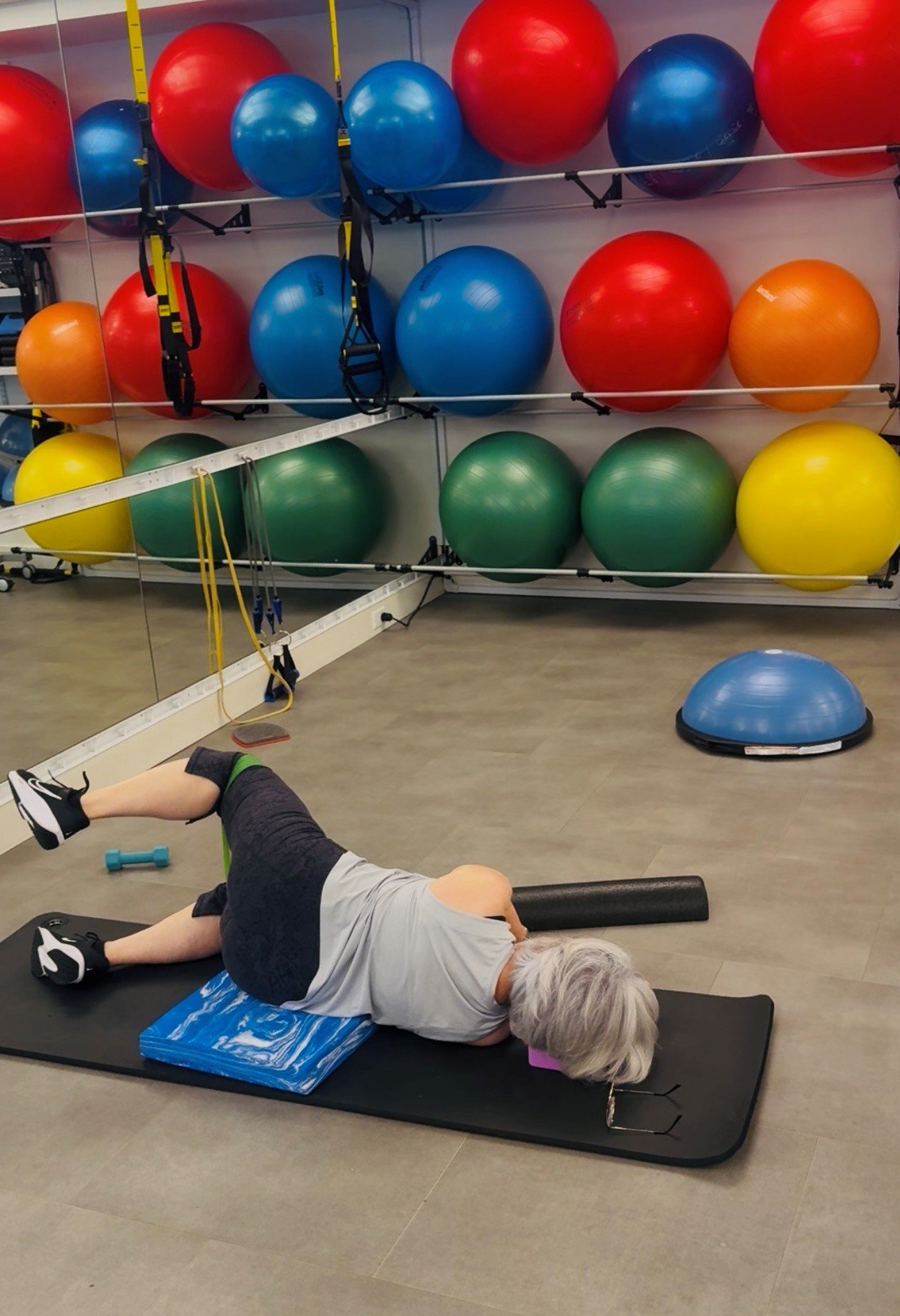 Client doing a glute and lower-body strengthening exercise in a hip rehab class