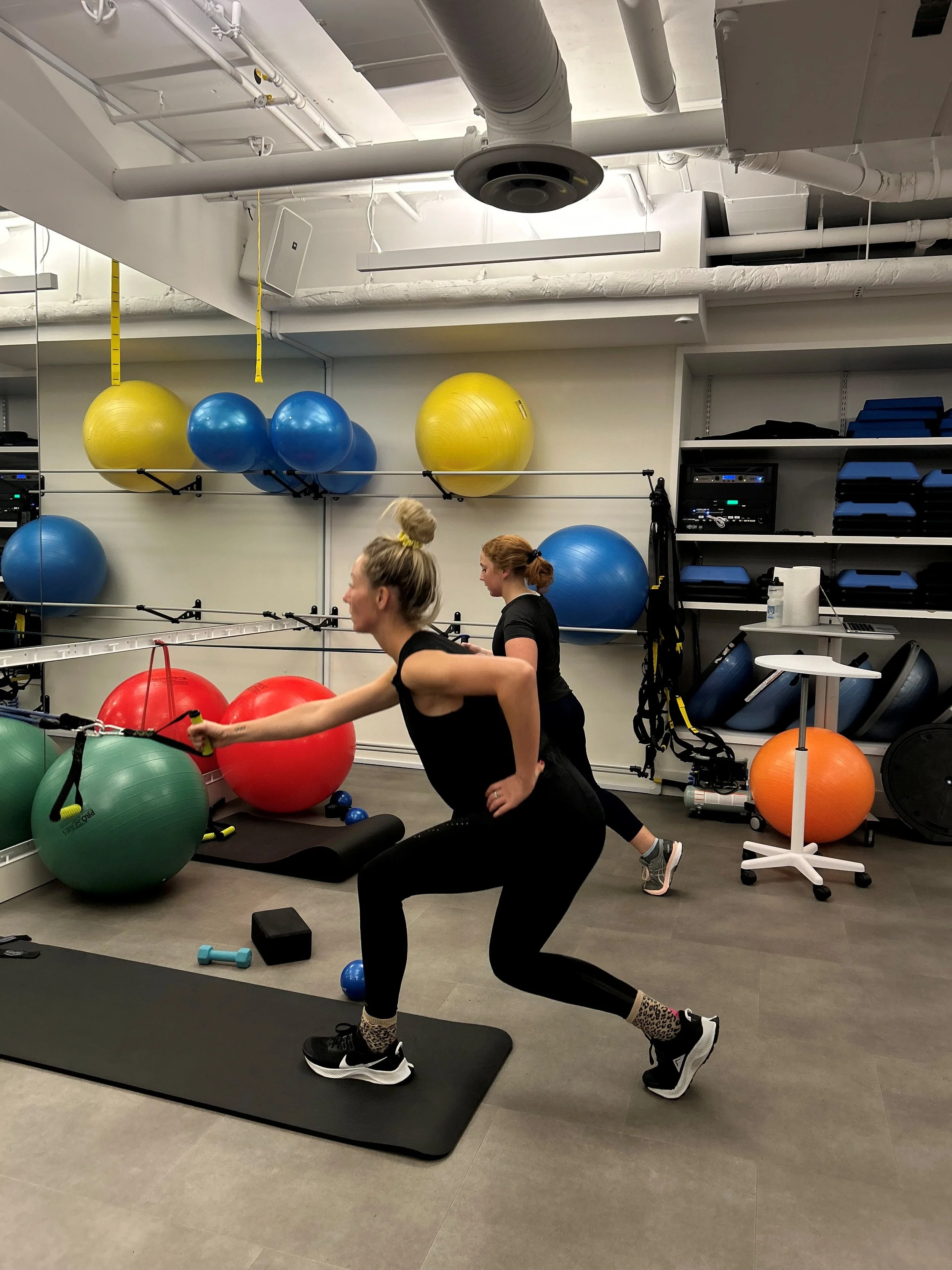 Women lifting weights and using resistance bands in a menopause strength class in North Vancouver
