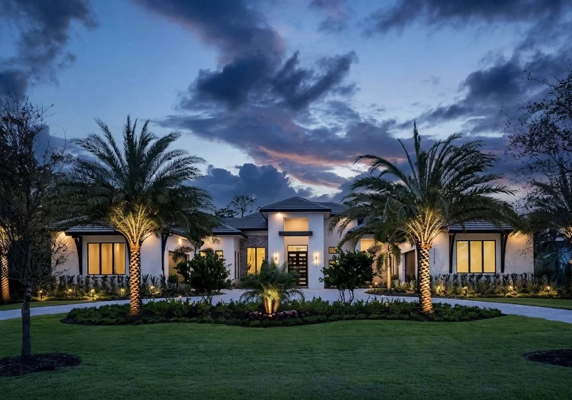Modern house with palm trees and landscaped garden at dusk