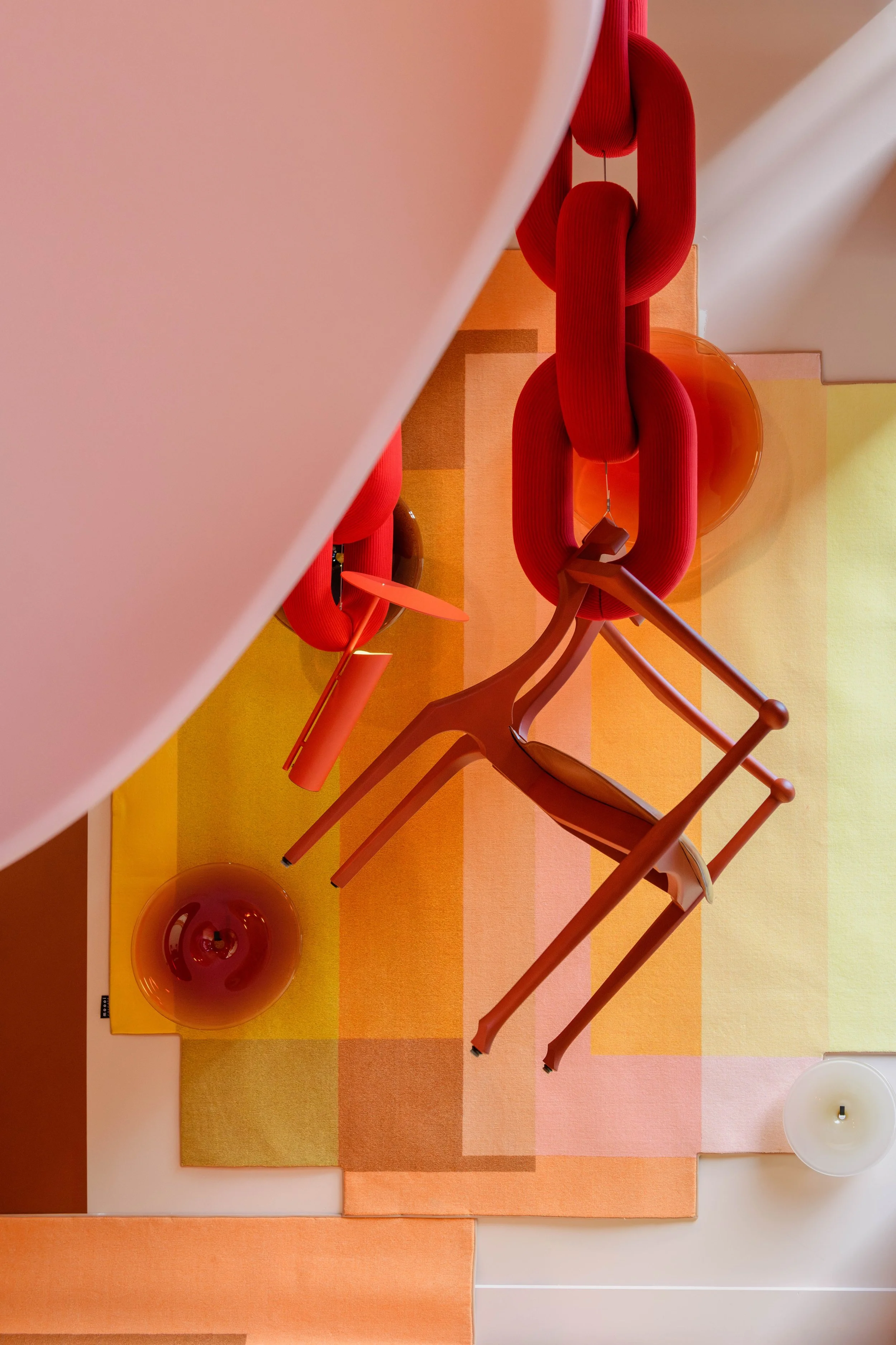 Colorful modern interior with a table, two chairs, and decorative objects in shades of orange and red.